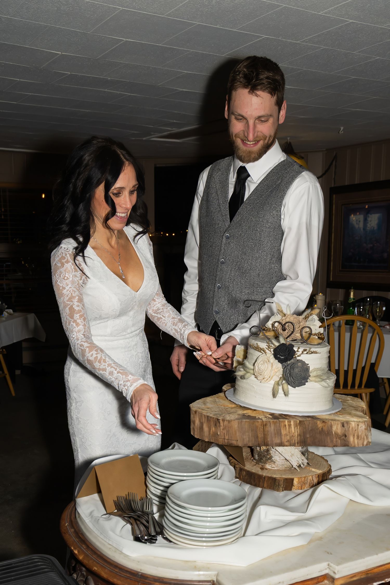 Couple cutting their wedding cake together at the reception table.