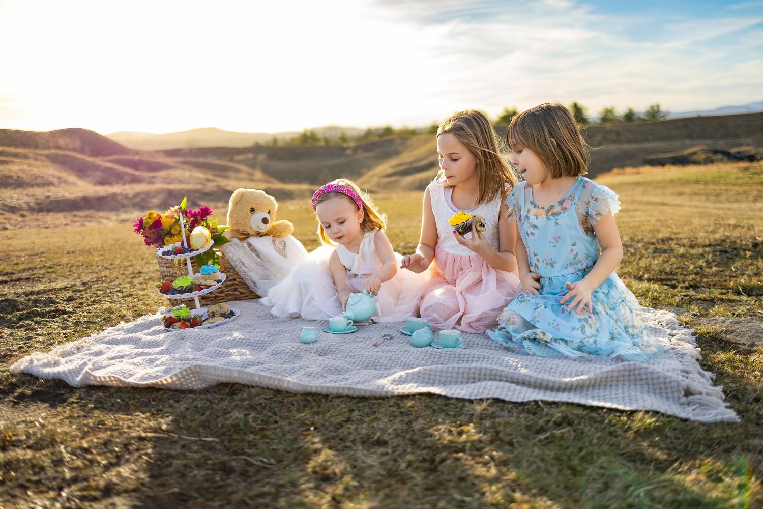 Group relaxing on picnic blanket during sunset outdoor photoshoot.