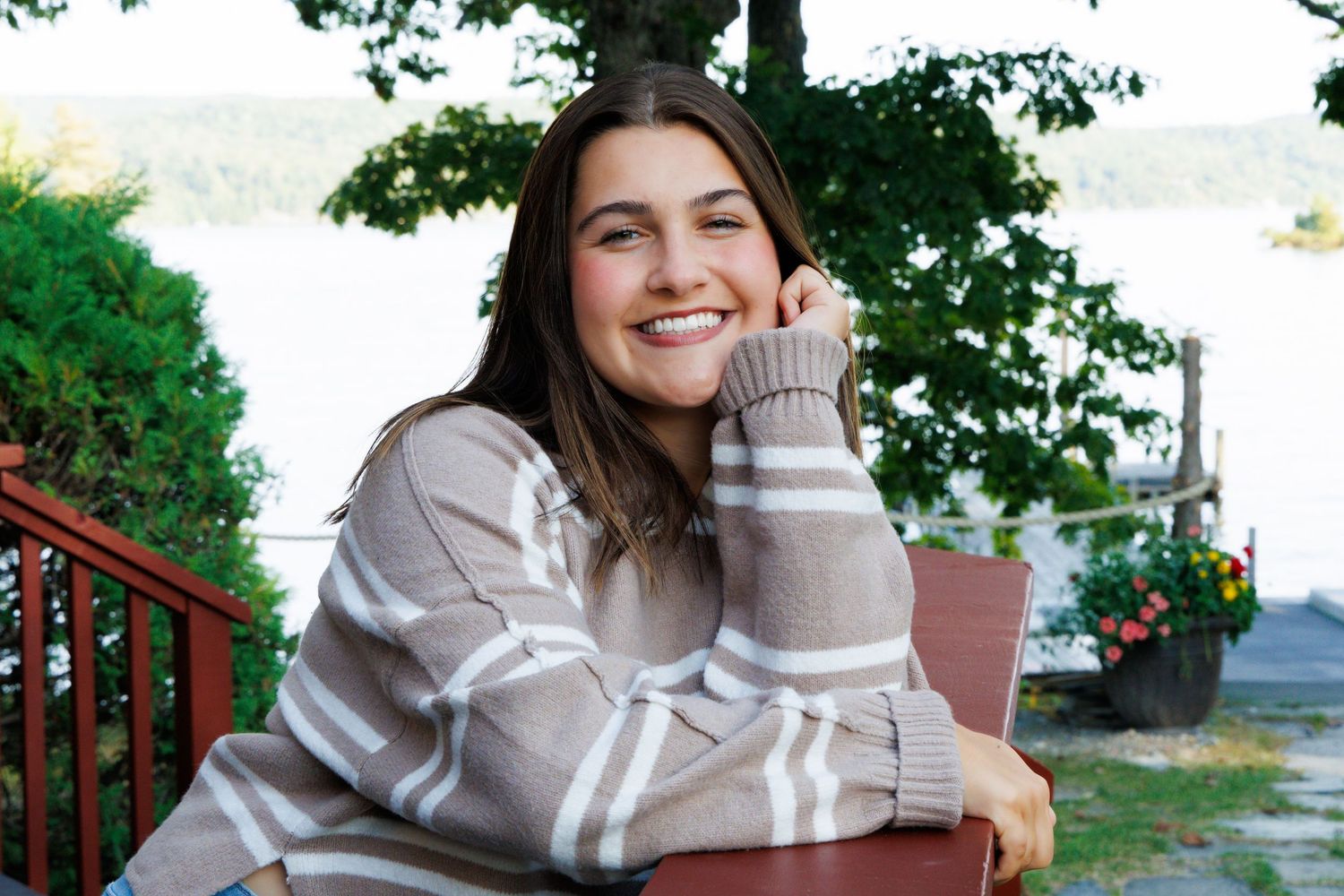 Outdoor portraits on porch featuring striped gray sweater and casual styling.
