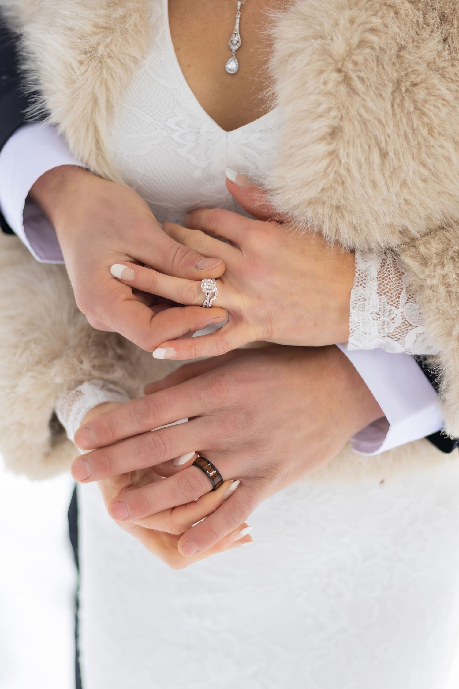 Close-up series showing hands with engagement and wedding rings against a white fur background.
