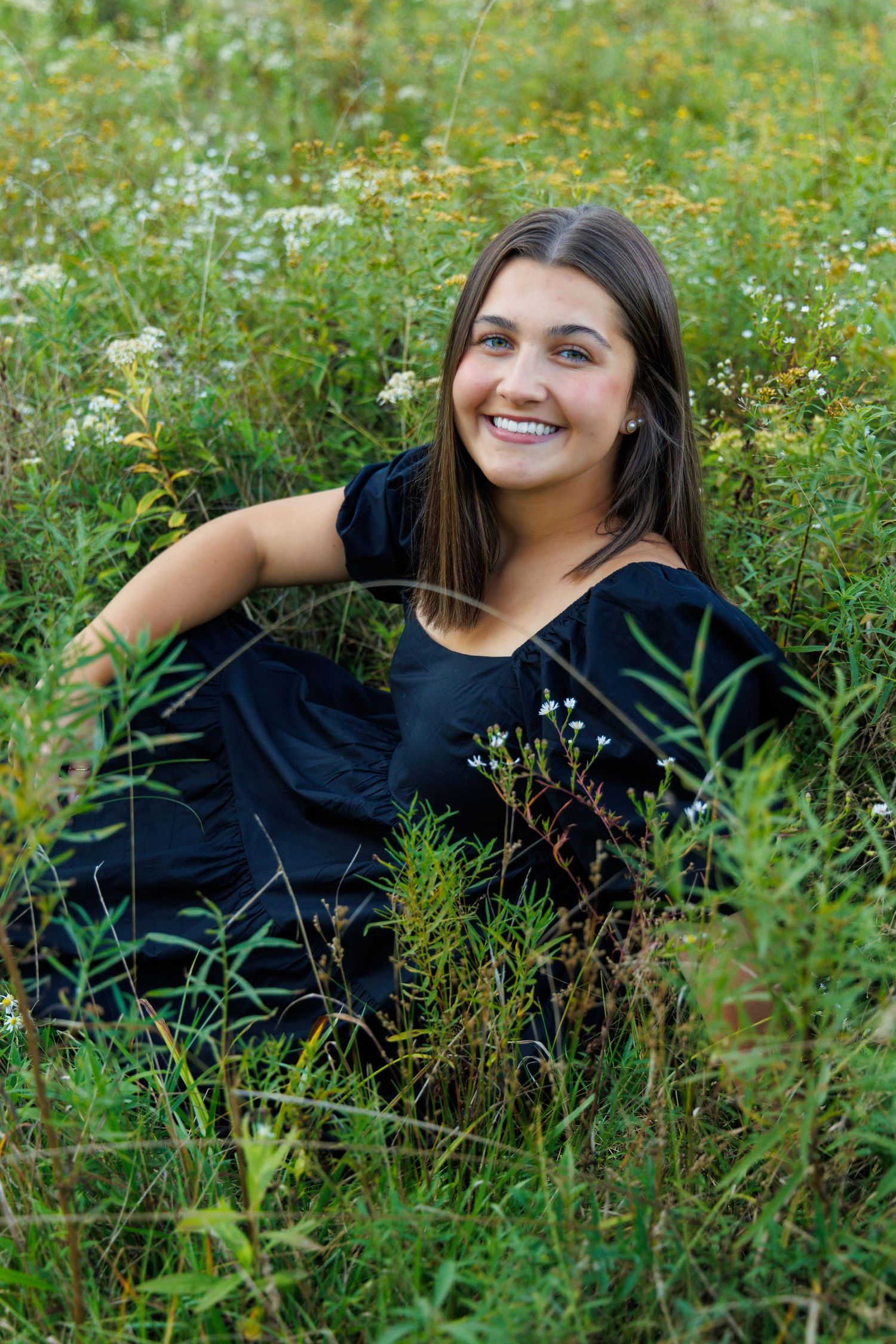Portrait session in a wildflower meadow with natural summer lighting.