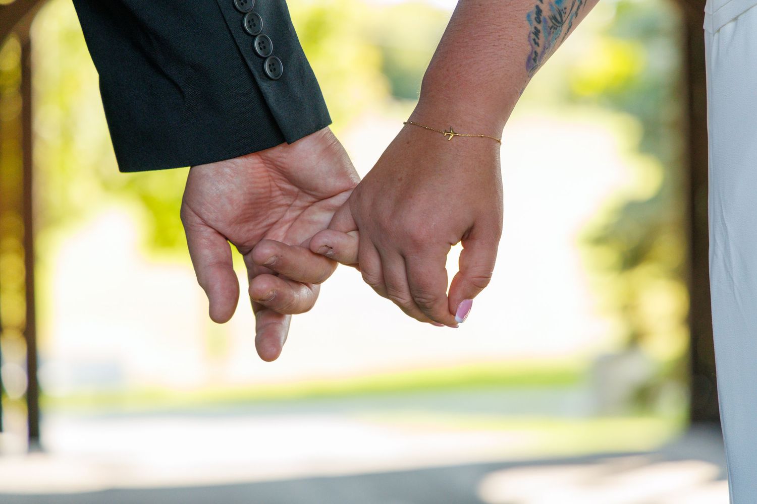 Close-up of hands holding during an outdoor wedding ceremony.