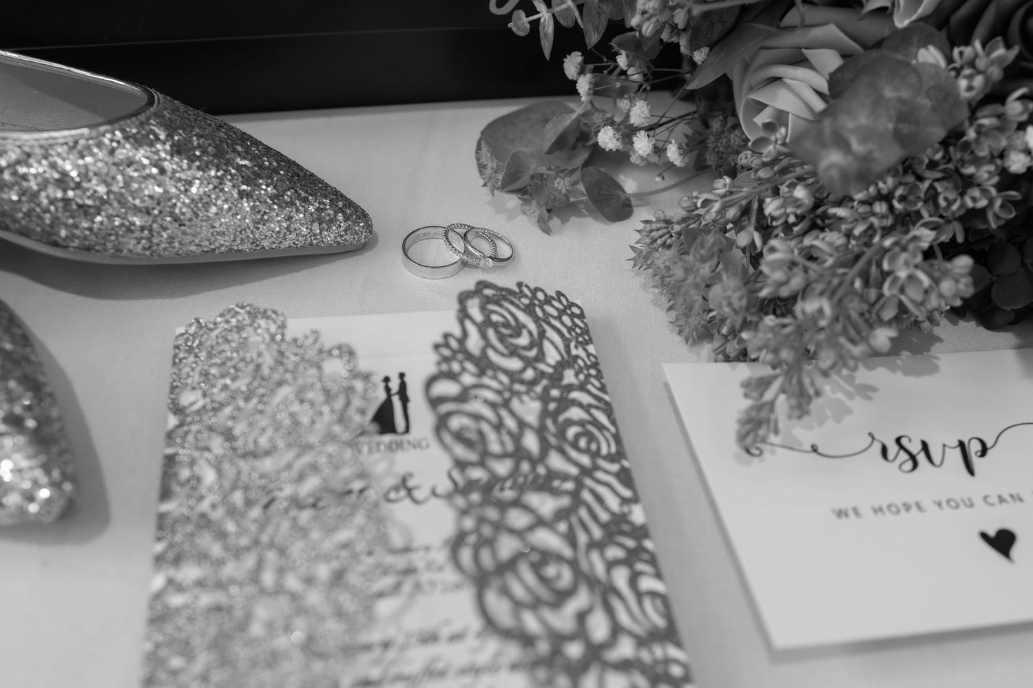 Elegant wedding invitations with intricate lace patterns in black and white.