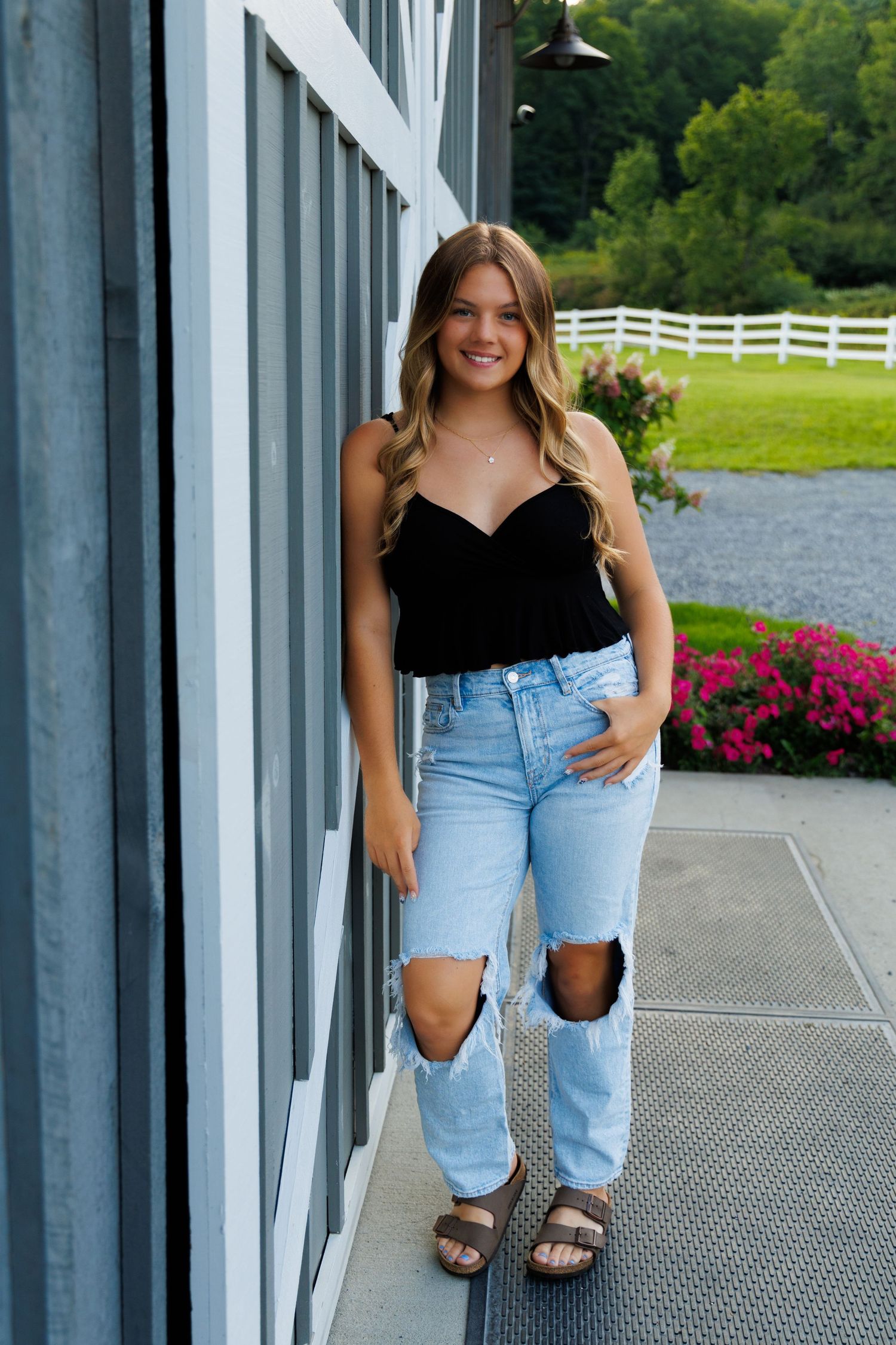Casual portraits in denim and black top on modern architectural walkway.