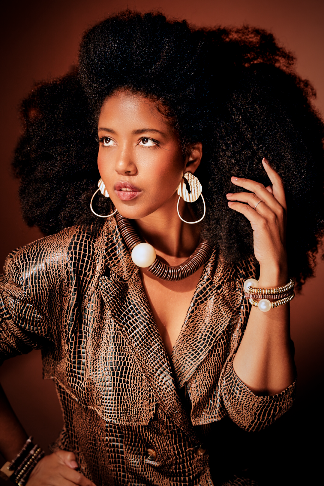 Glamour shot showcasing metallic snakeskin pattern top and bold hoop earrings.