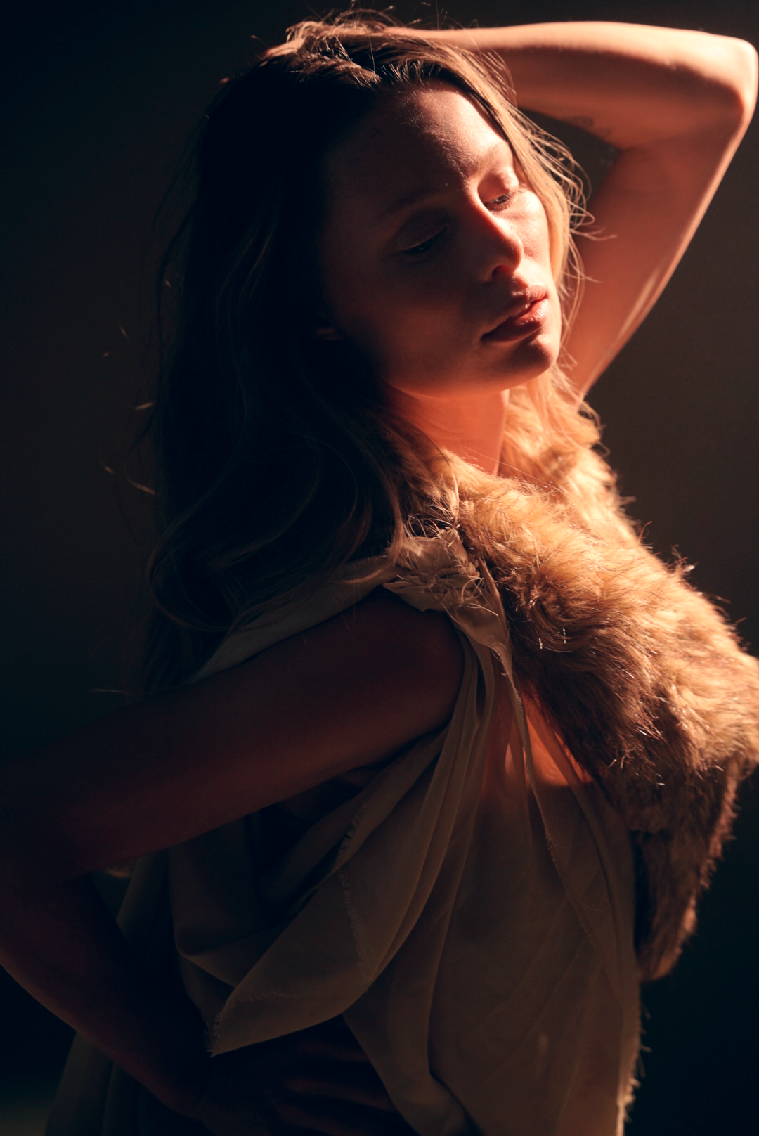 Ethereal portrait in soft lighting with flowing fabric creating dramatic movement.
