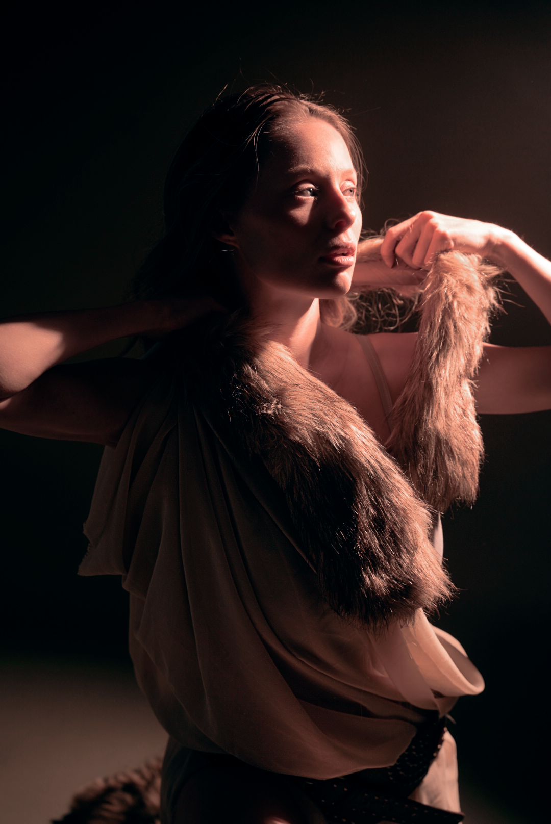 A moody profile shot with dramatic lighting against a dark background.