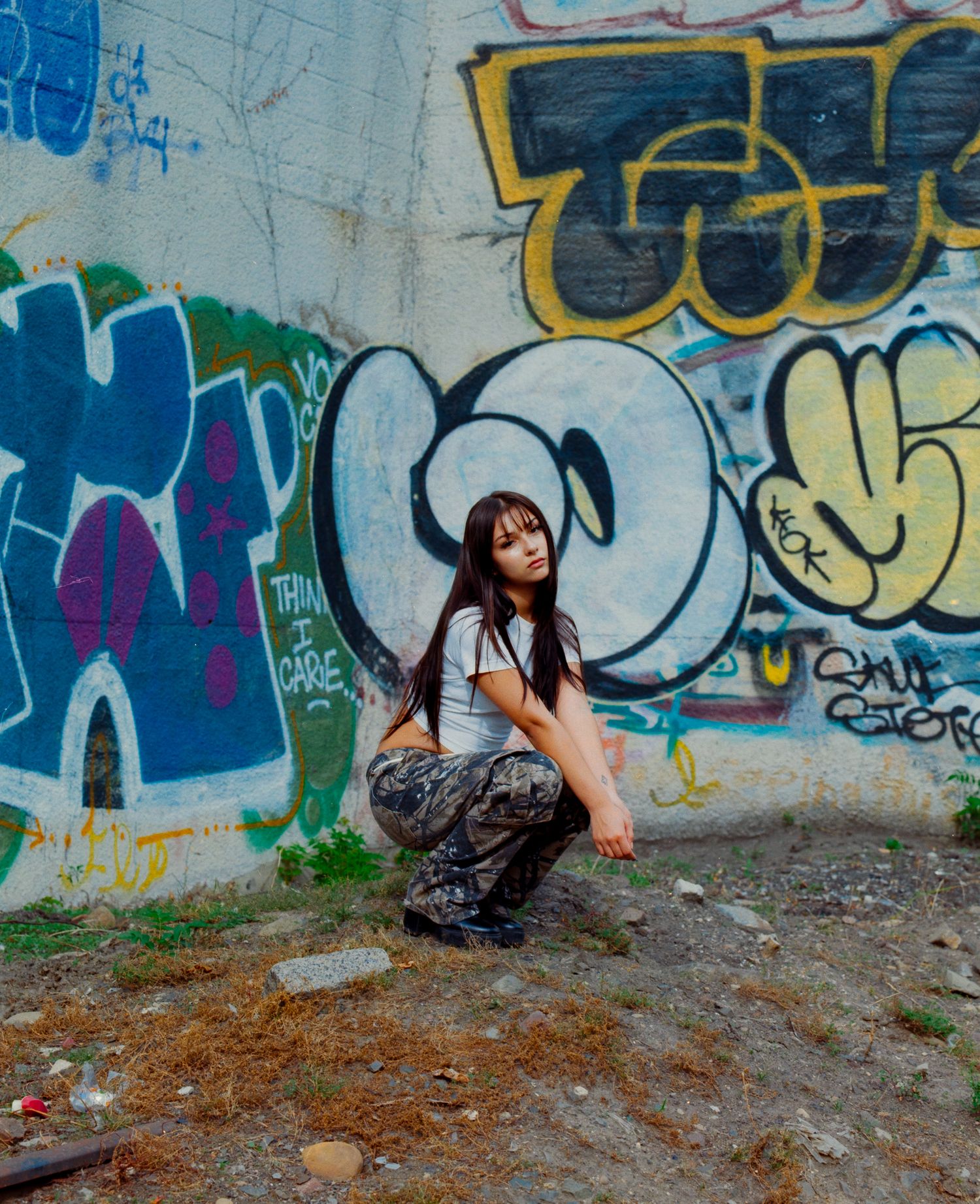 Urban photoshoot with graffiti wall backdrop in casual setting.