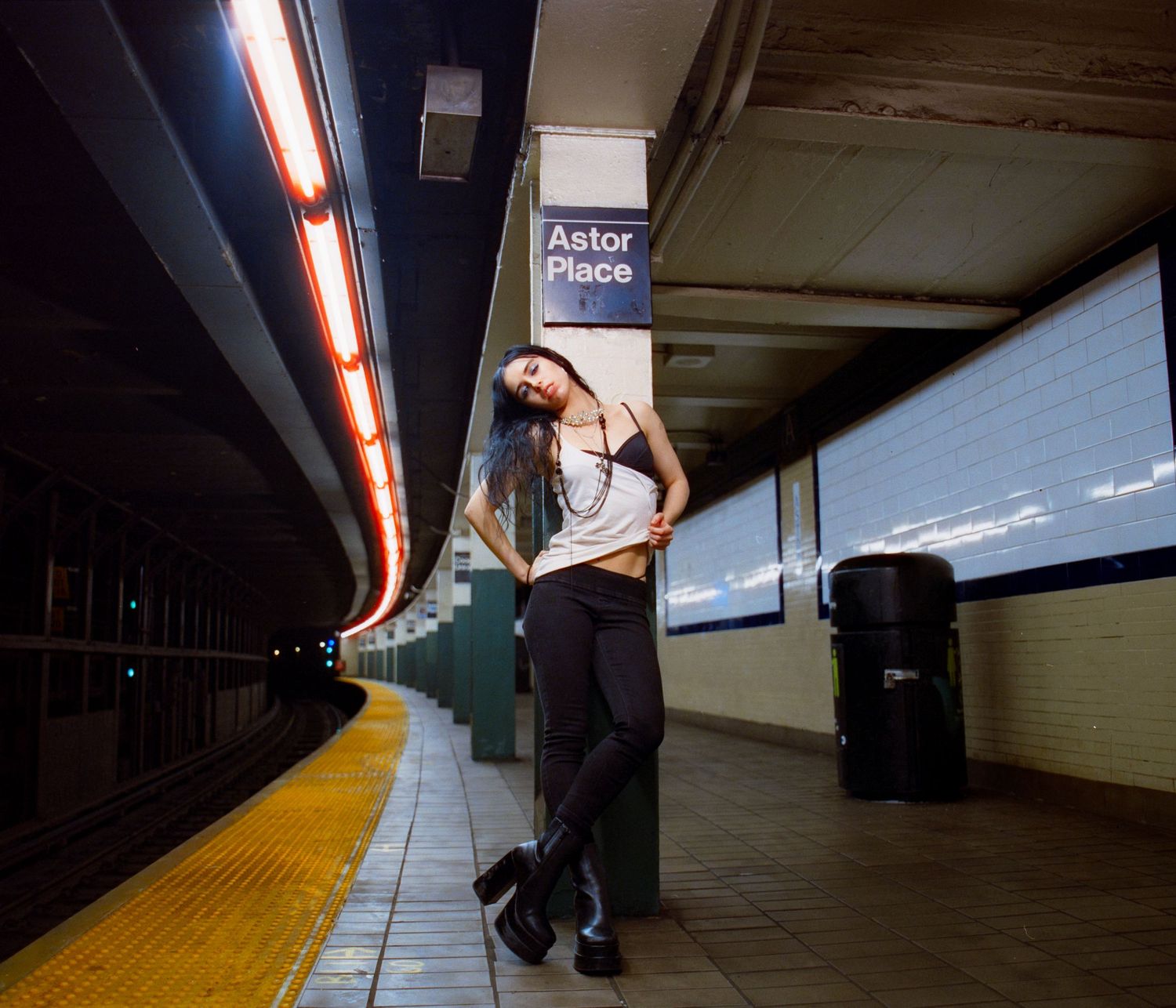 Subway platform scene with yellow safety strip and fluorescent lighting.