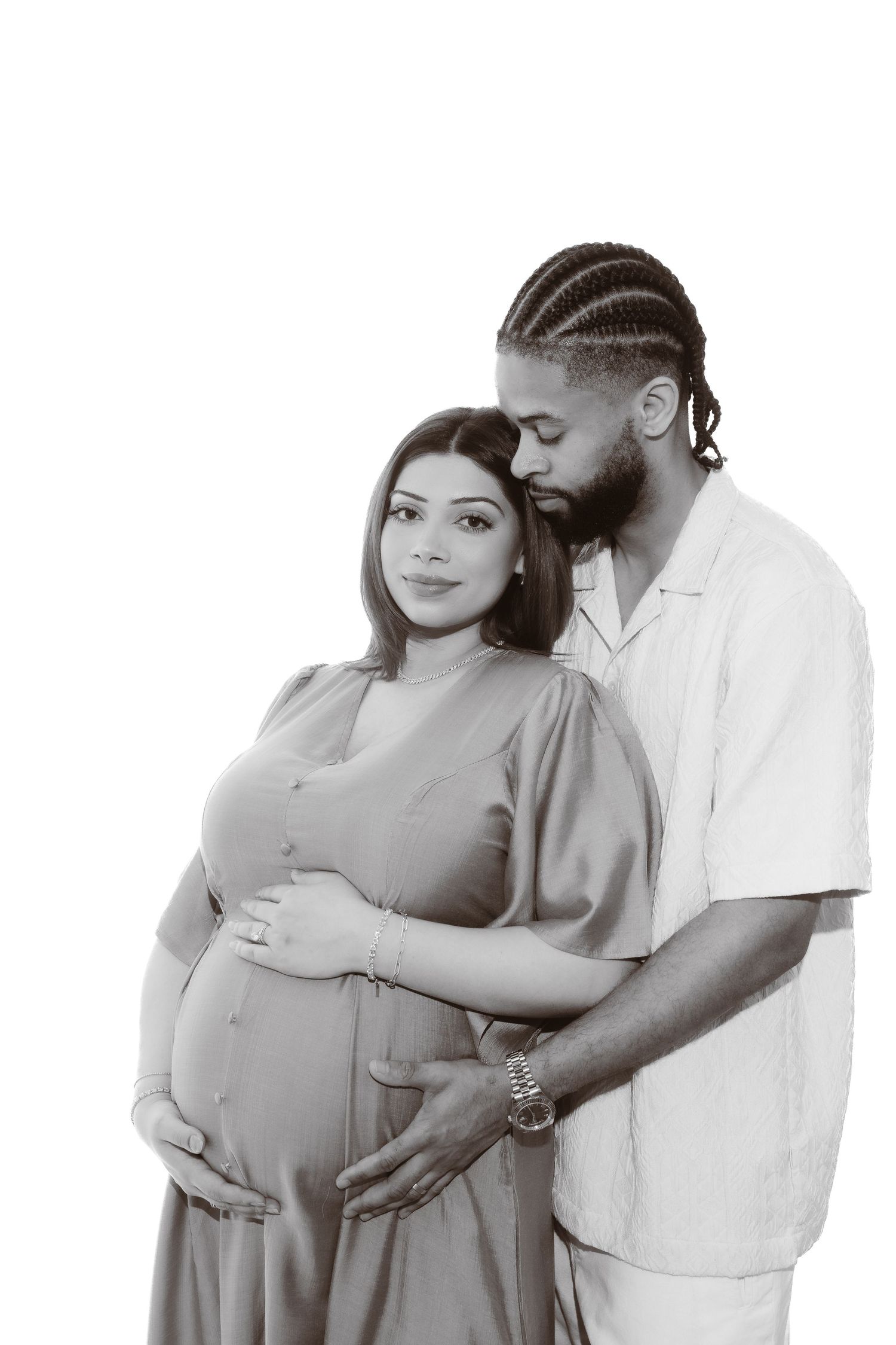Black and white maternity photo series showing intimate moments between an expectant couple in tender poses.