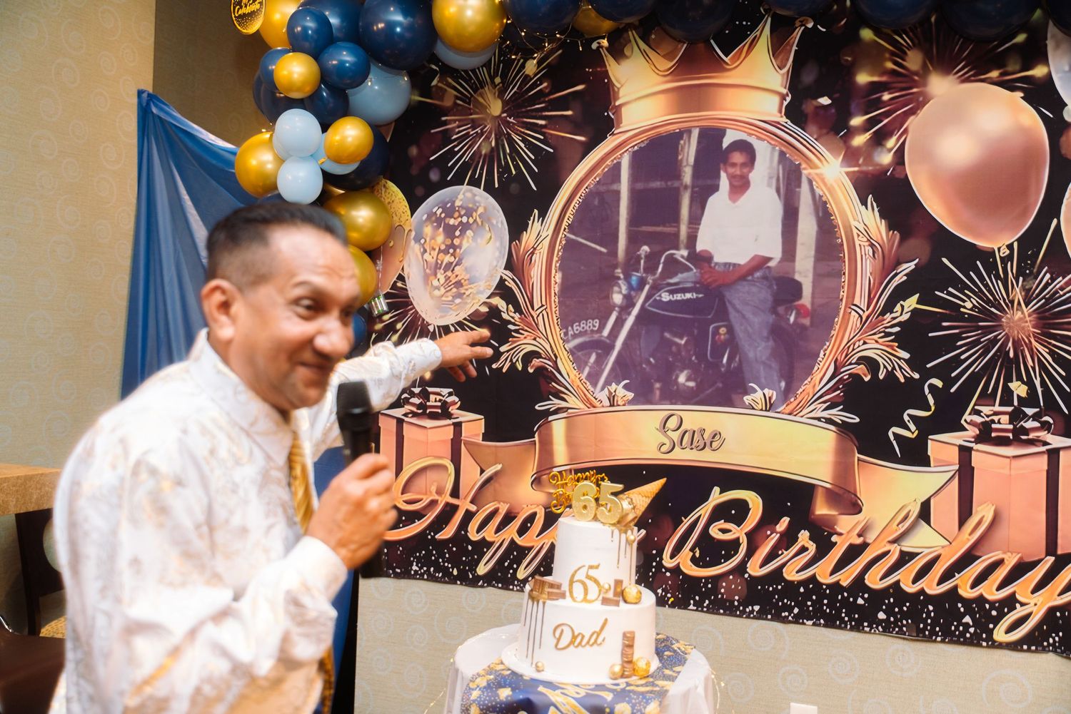A celebratory birthday event with balloons, firework decorations and a birthday cake display.