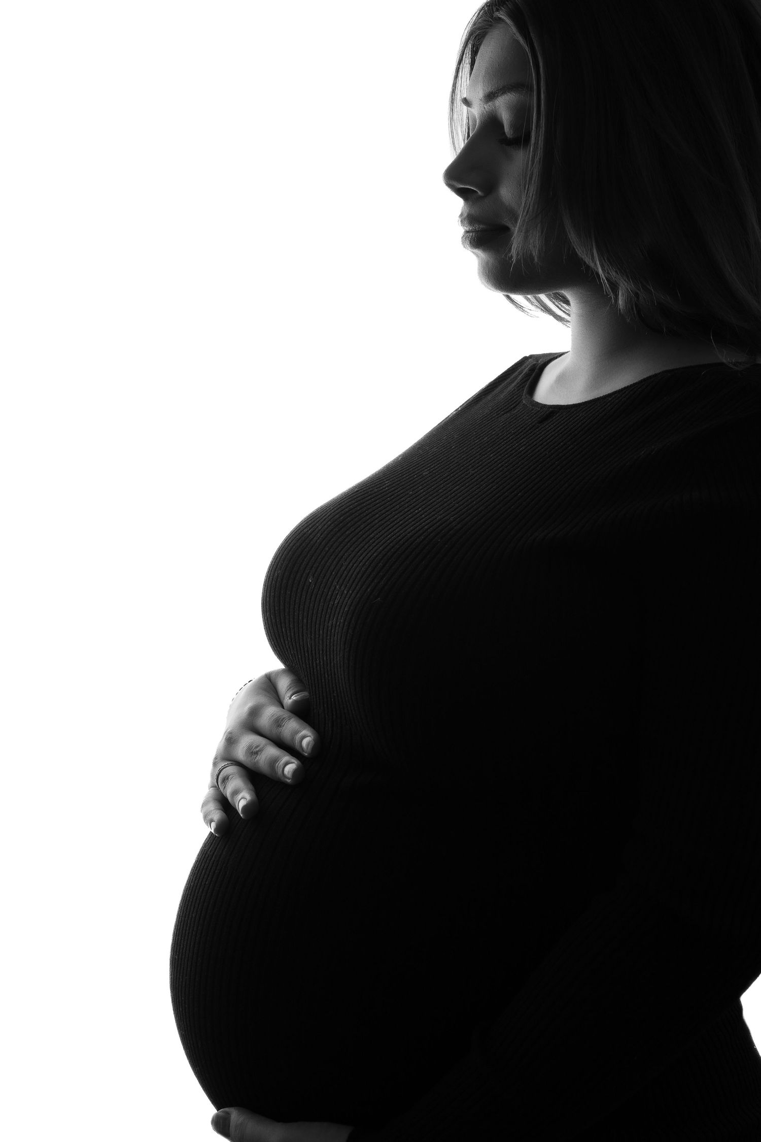 Black and white artistic maternity photo series showing silhouetted pregnant belly from different angles.