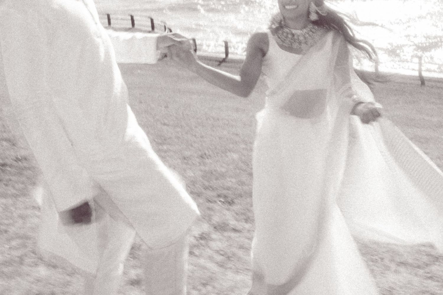 A romantic photoshoot sequence on a sandy beach with flowing white outfits.