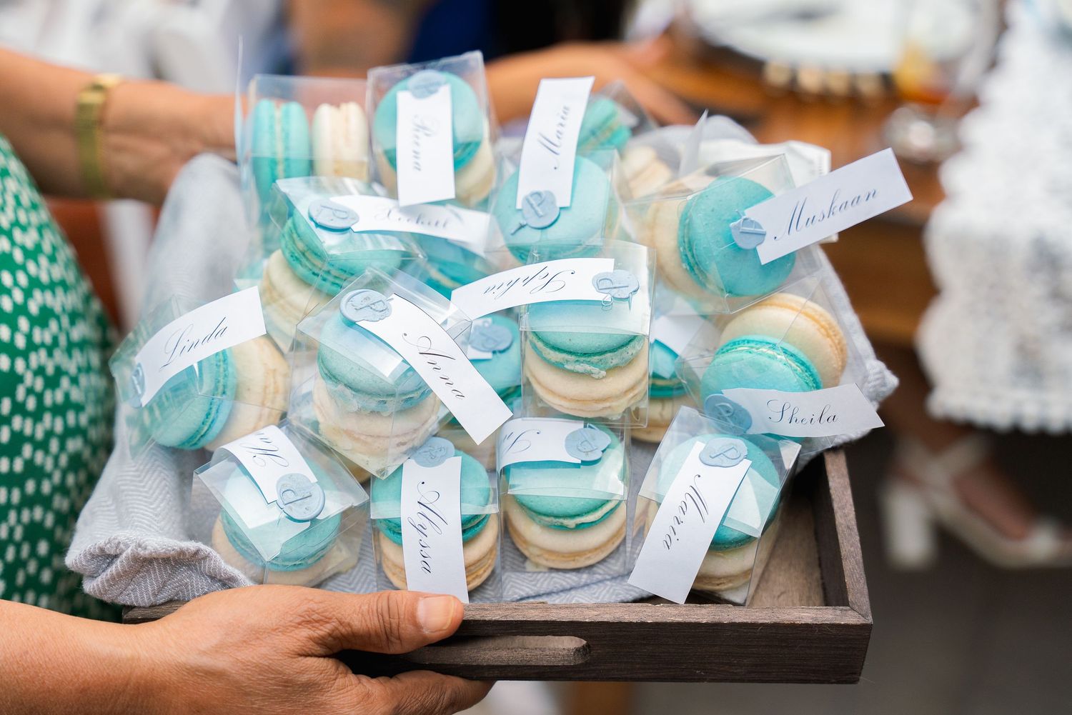 Turquoise and white decorated party favors arranged on wooden trays.