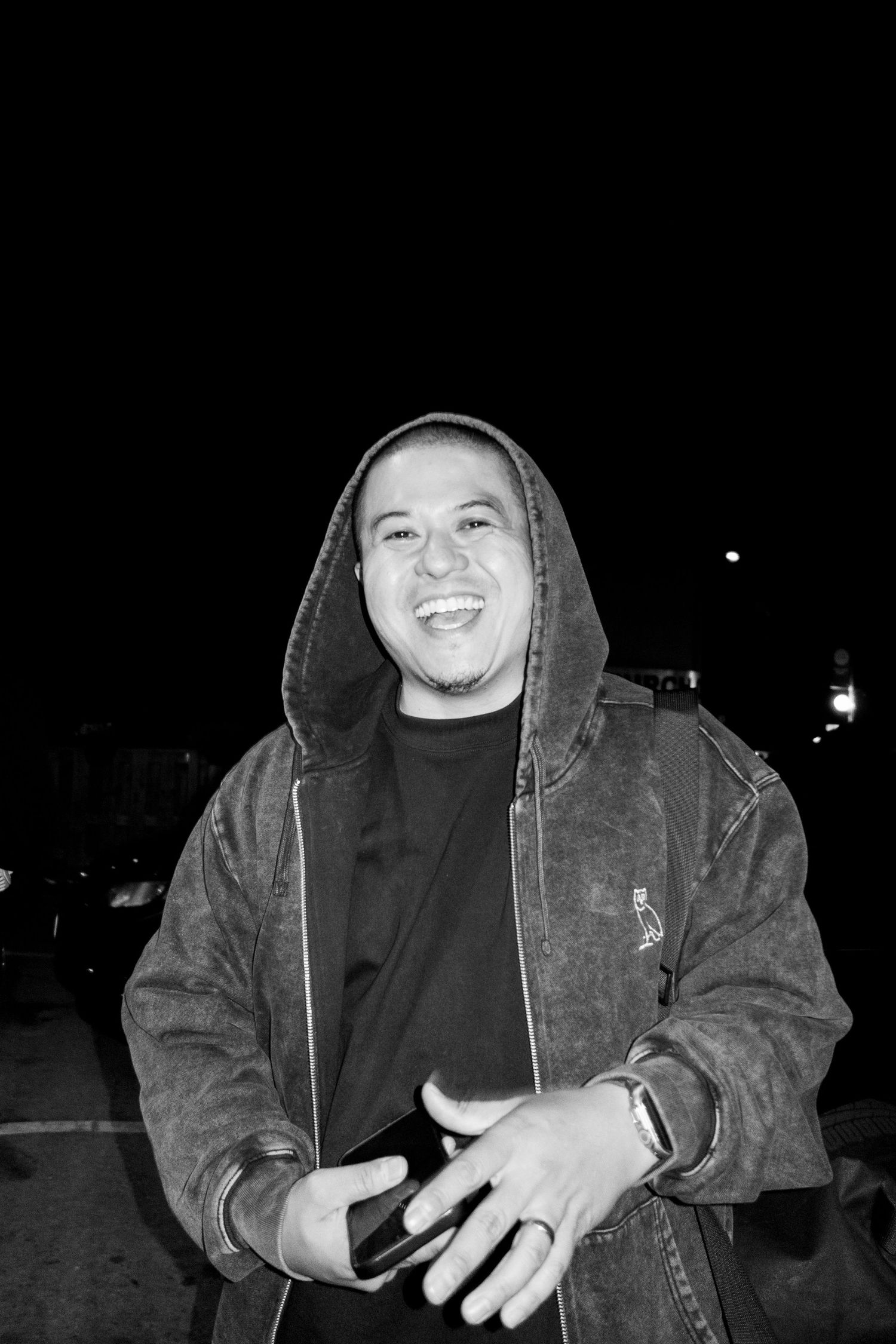 Person in hooded jacket photographed at night with expressive lighting.