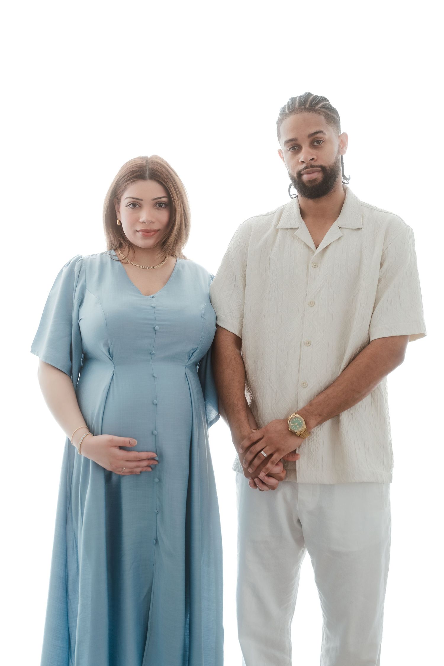 A couple in matching blue dress and white outfit pose together in a series of progressive shots against white background.