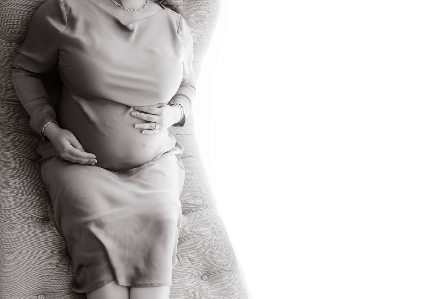 A white ceramic sculpture of a sleeping baby rests on a light colored surface.