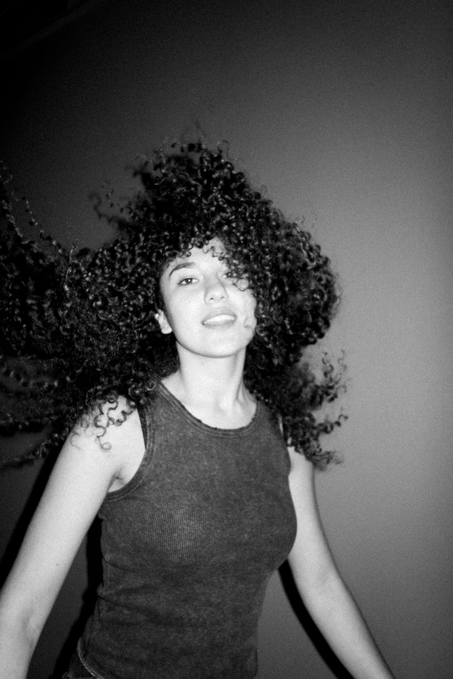 Dynamic black and white photo sequence showing curly hair in motion.