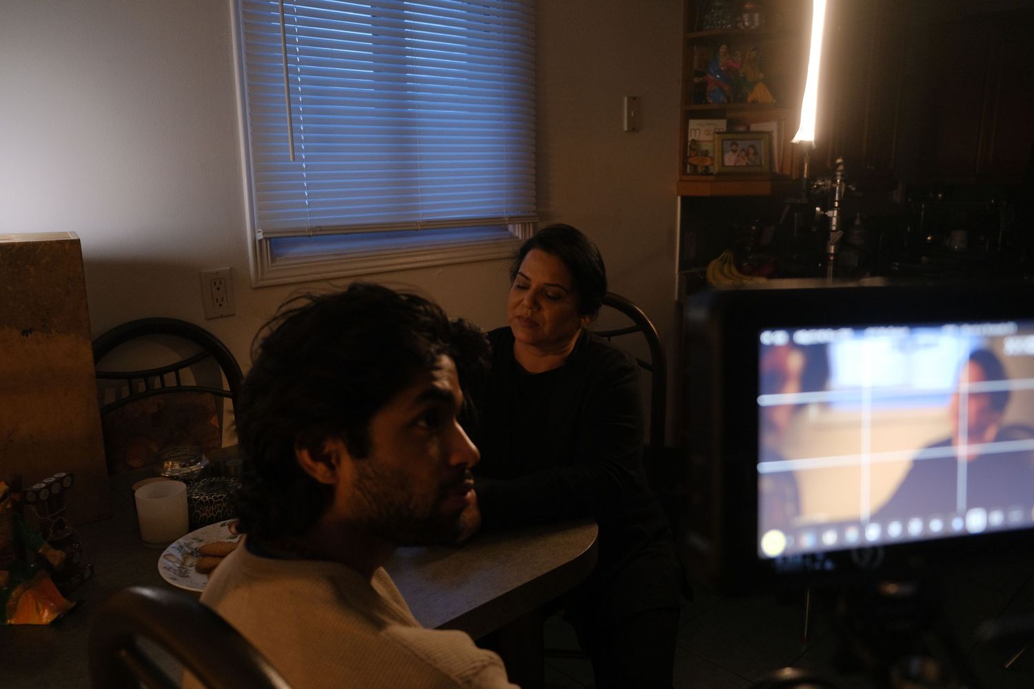 Group of people working in a dimly lit room with computer screens.
