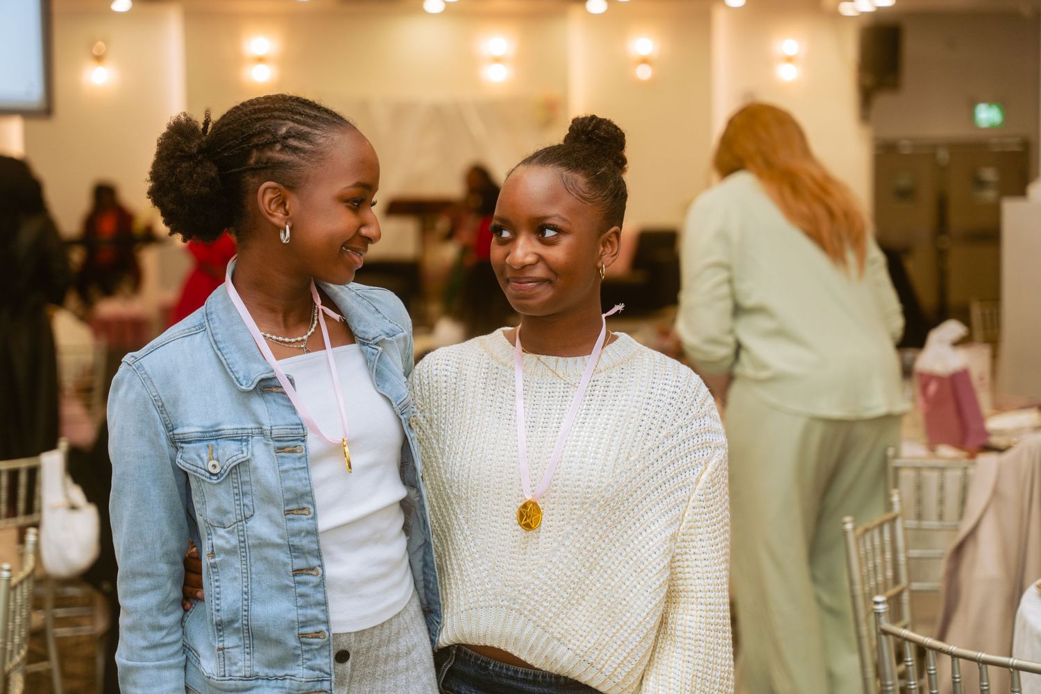 Guests in casual outfits engaging in conversation at an indoor event venue.