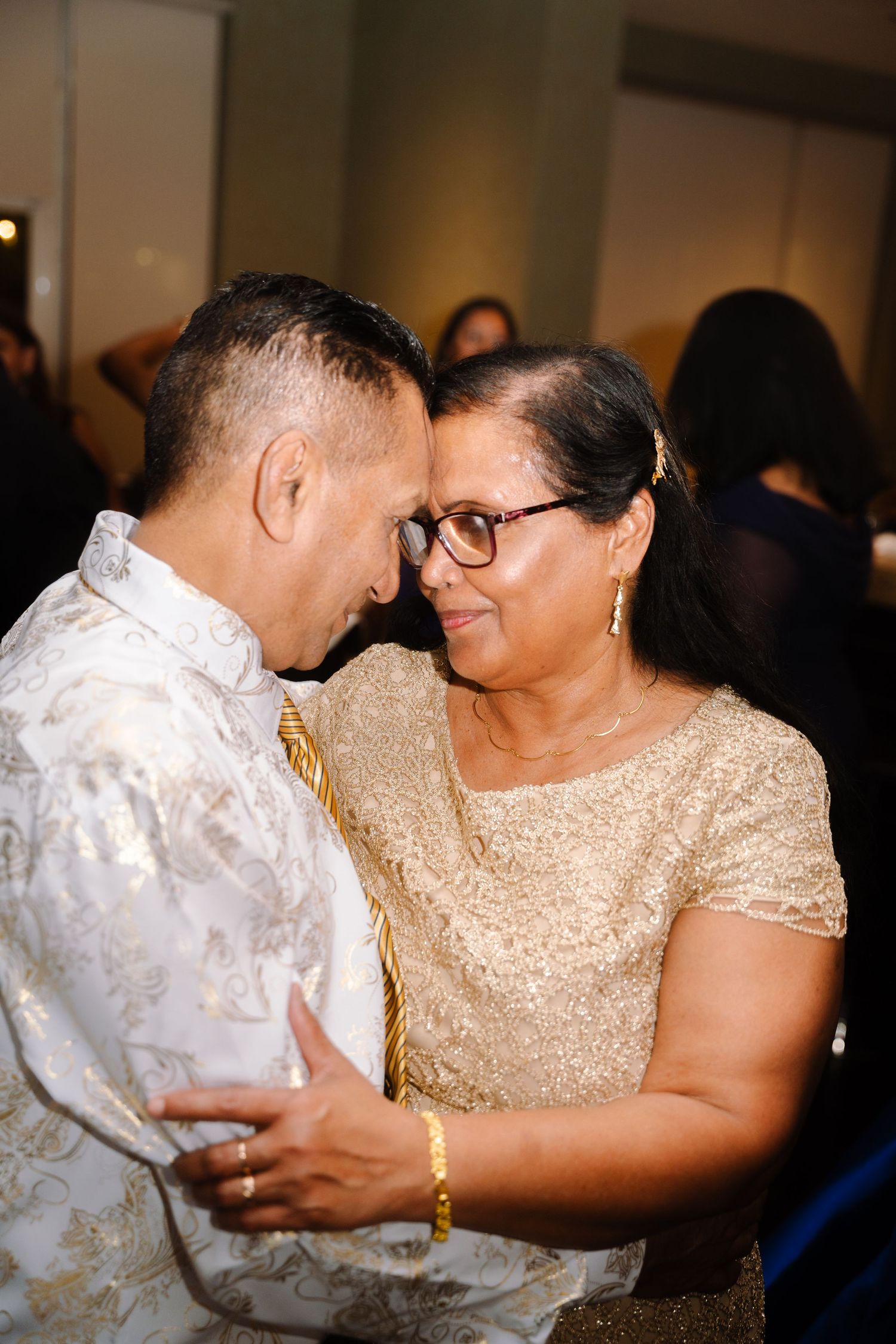 An emotional dance moment between family members at a wedding reception.