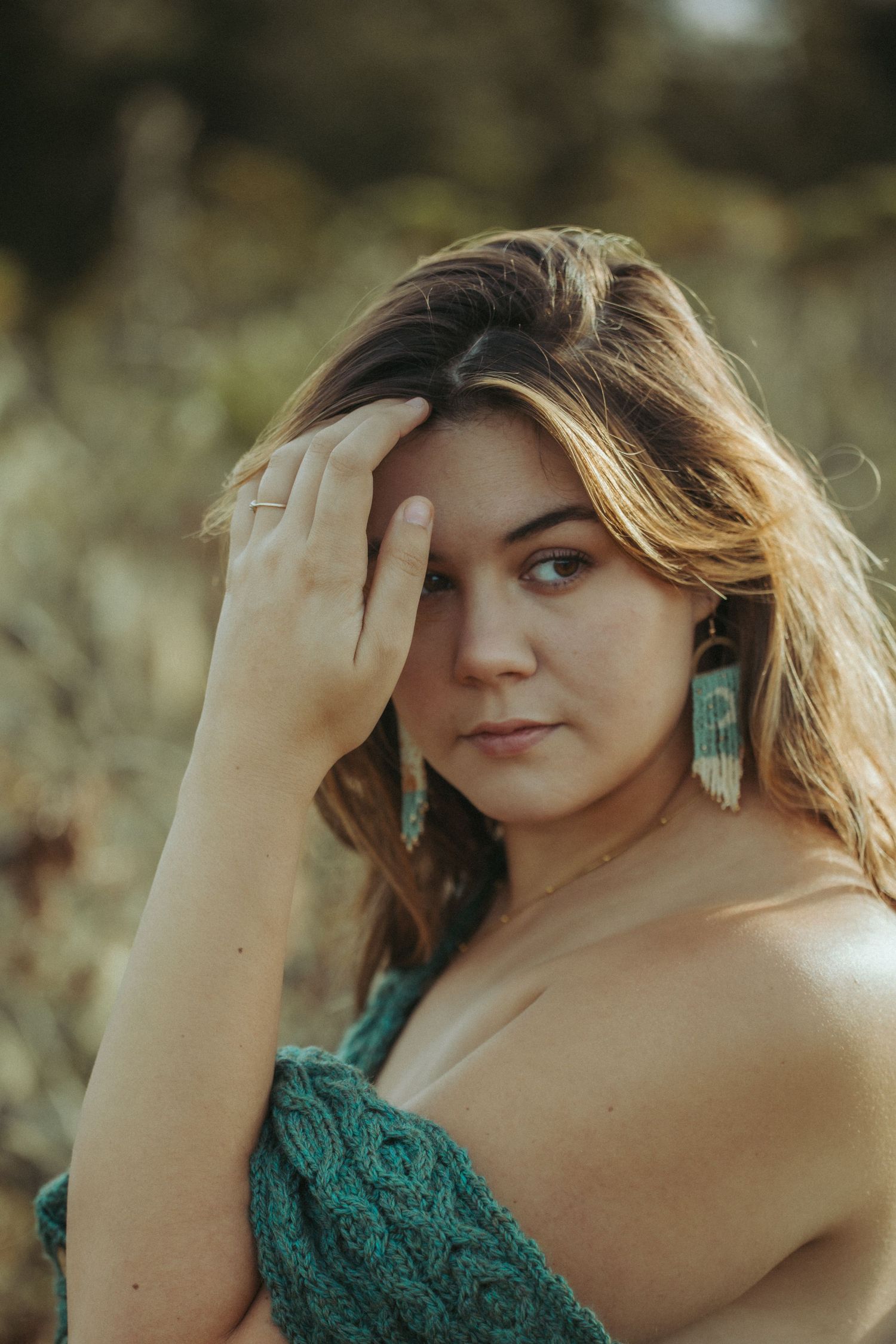 A person in a green lace top poses outdoors with soft sunlight filtering through their hair in a series of photos.