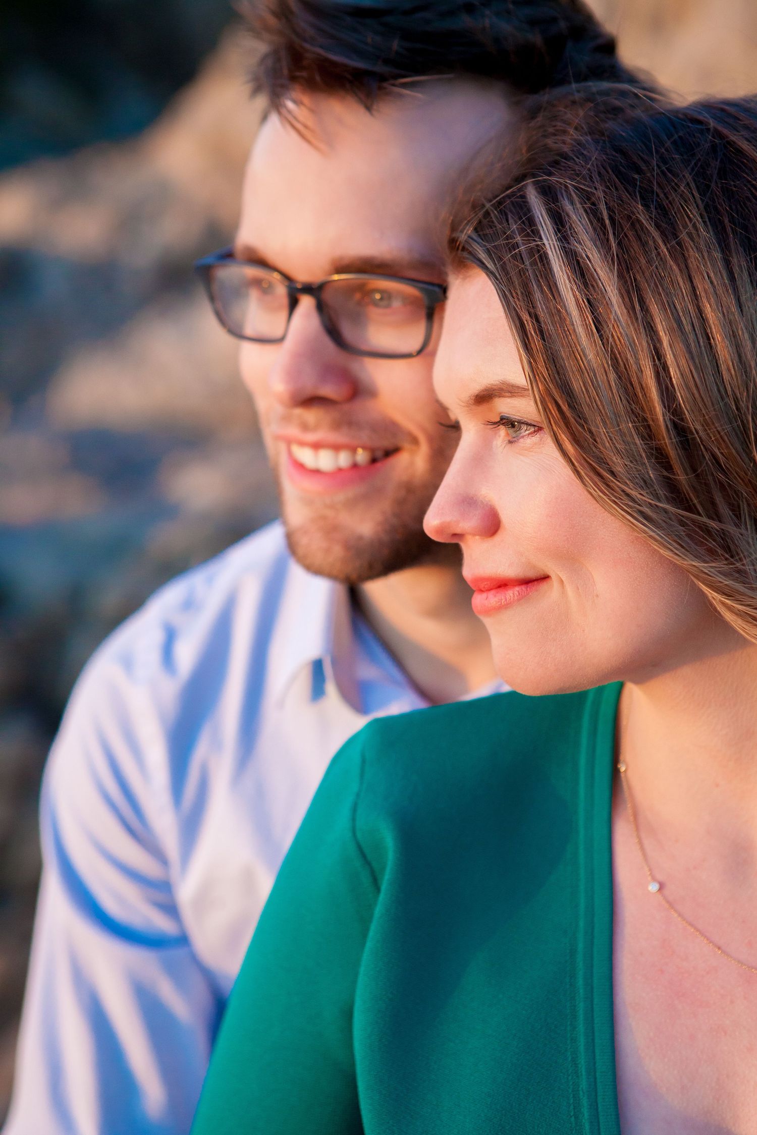 Close-up profile view of two people enjoying a sunny outdoor moment together.
