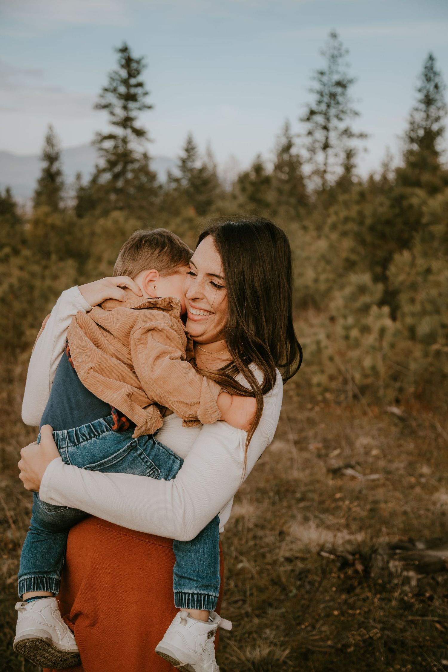 Three warm and intimate outdoor family photos showing loving embraces against a backdrop of evergreen trees at sunset.