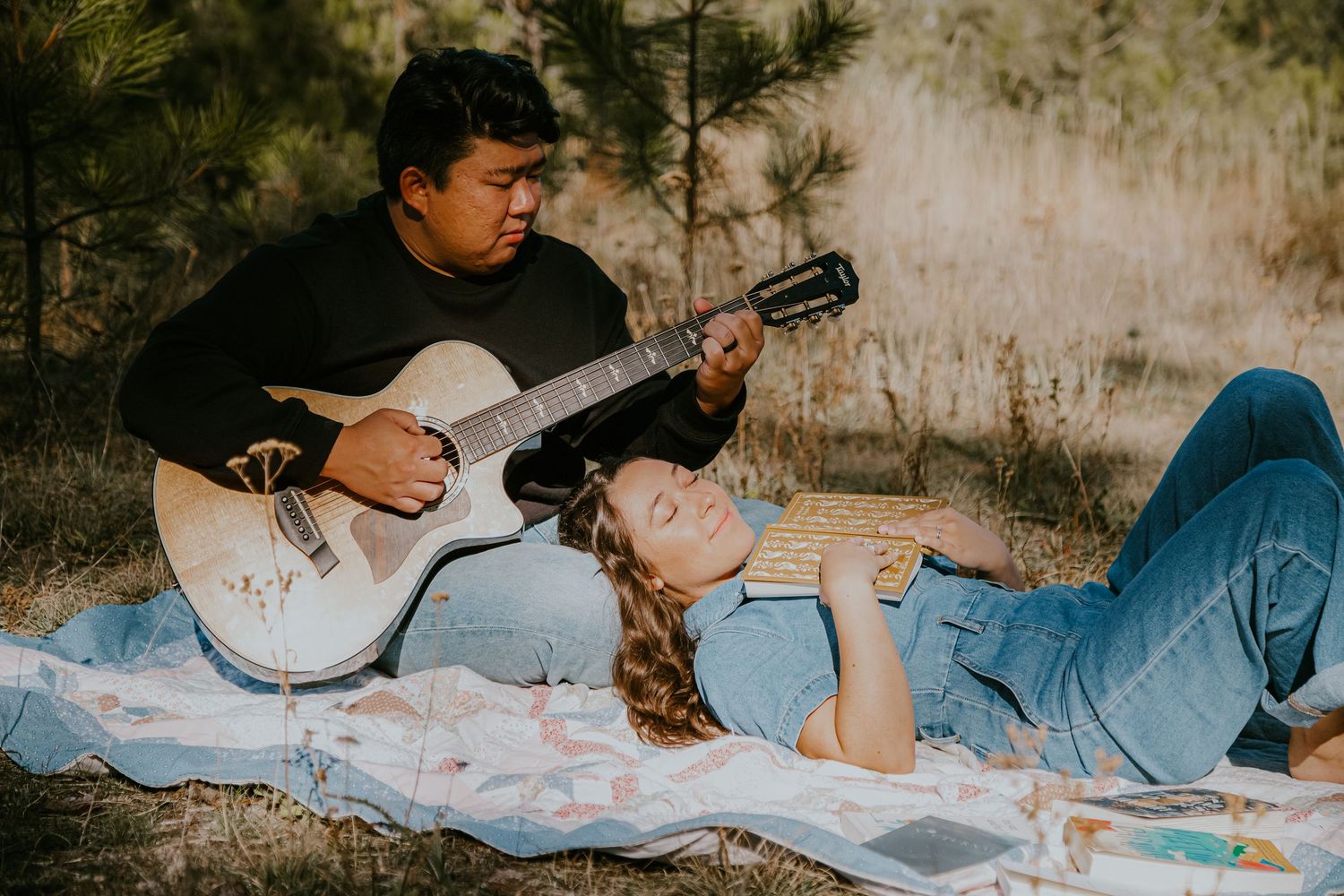 A series of connected images showing someone playing guitar while lying down on a light blue blanket outdoors.