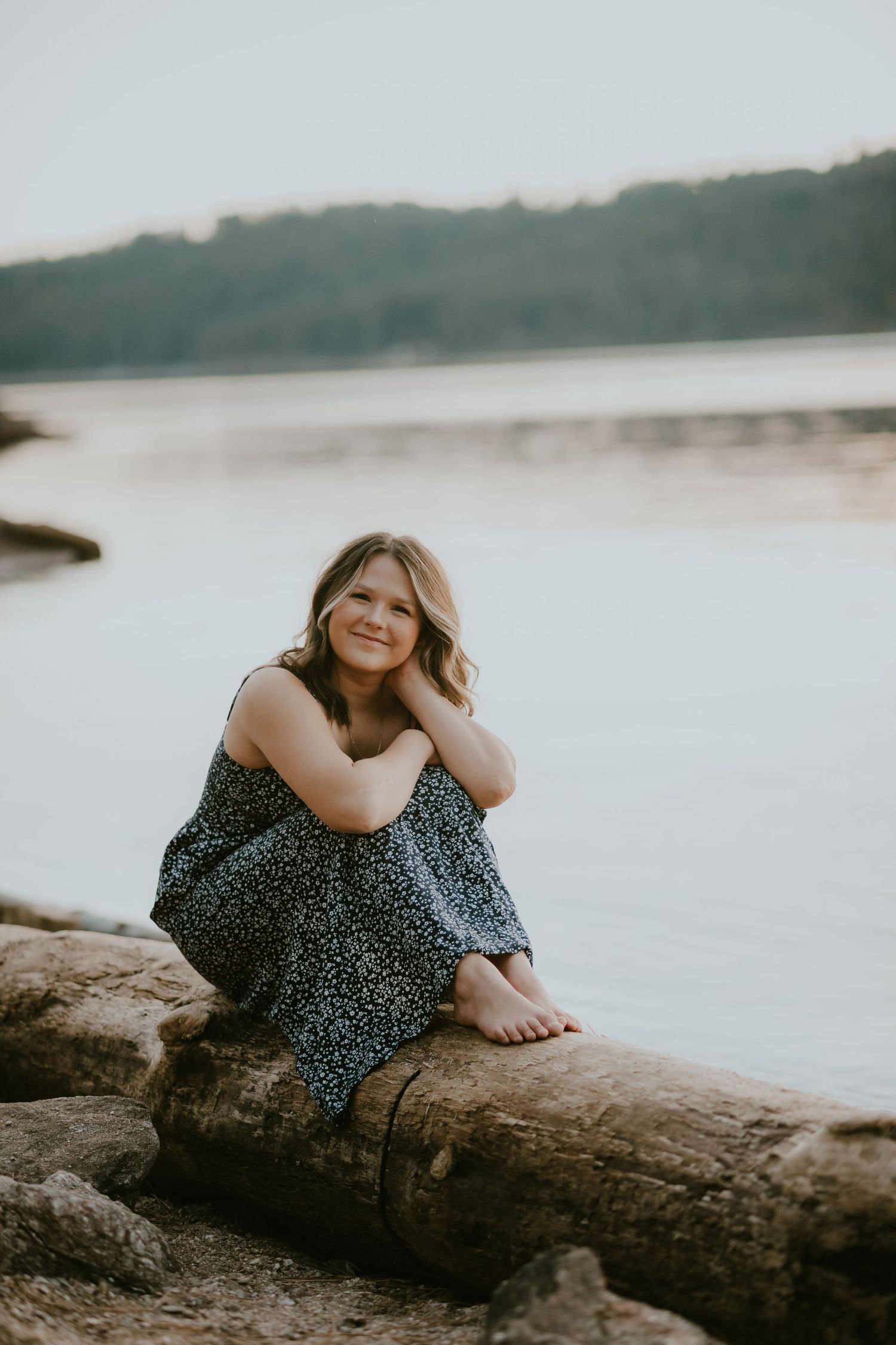 A sequence of portraits showing a person in a polka dot dress relaxing on a fallen log by a serene lakeside at sunset.