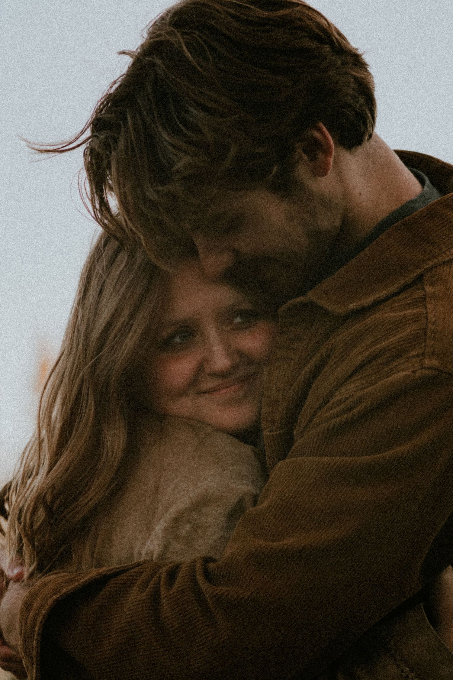 A romantic couple embraces intimately in a series of warm-toned photographs showing tender moments together.