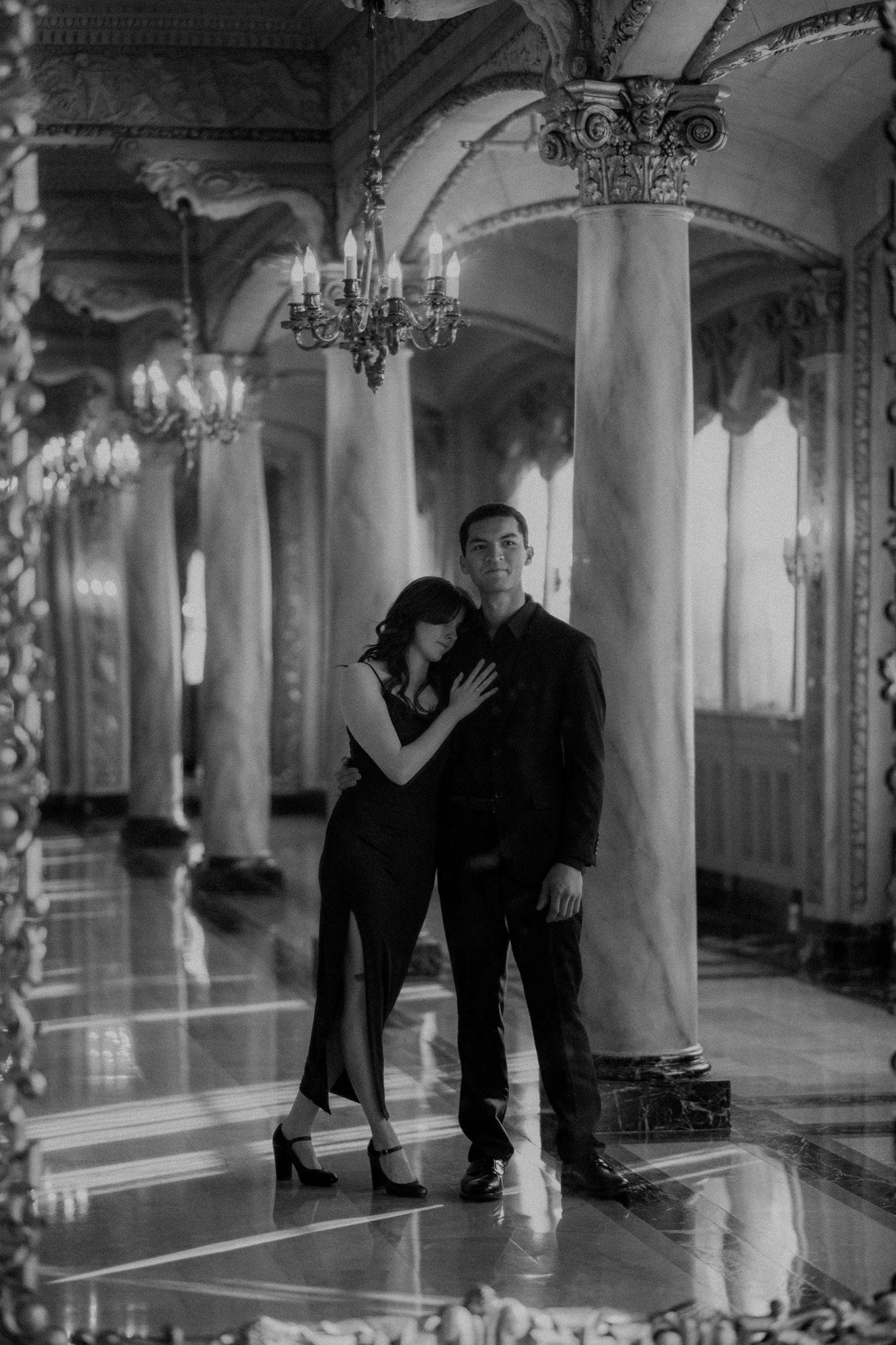 Black and white photo series showing dancers performing in an ornate ballroom with columns and chandeliers.