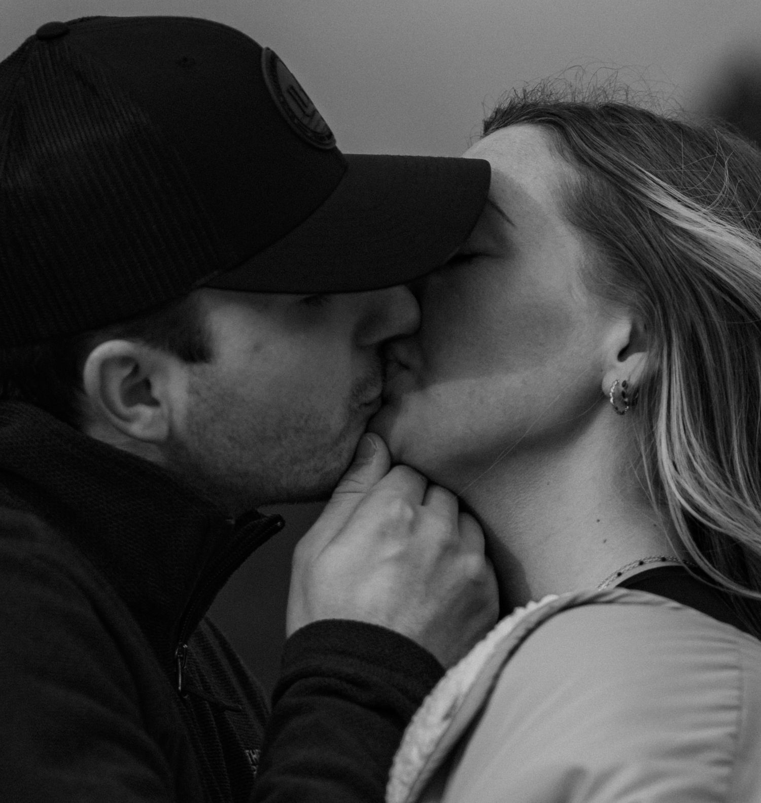 Romantic black and white close-up photo of a couple sharing an intimate kiss.