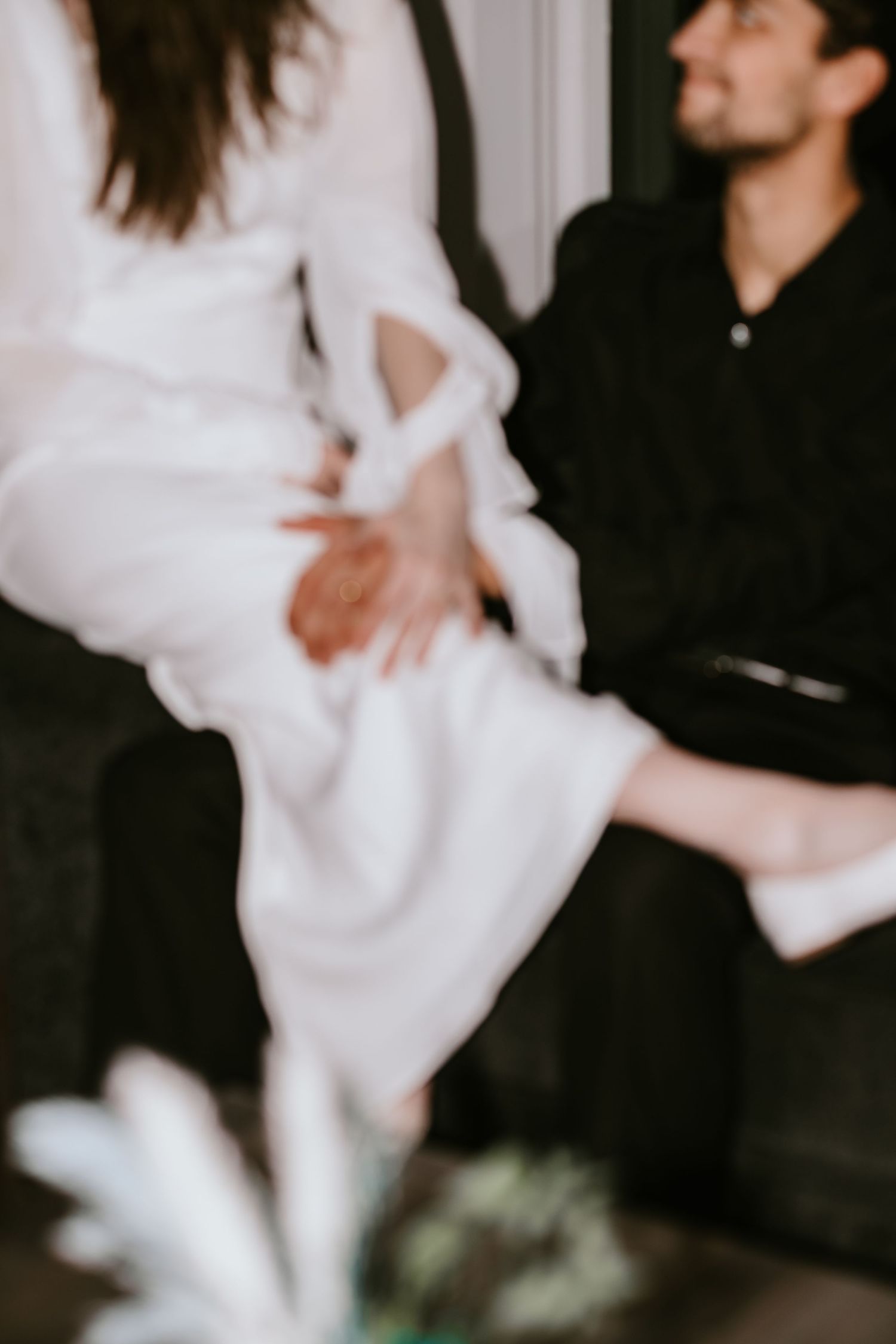 A dancer in flowing white fabric performs an ethereal contemporary dance movement against a dark background.