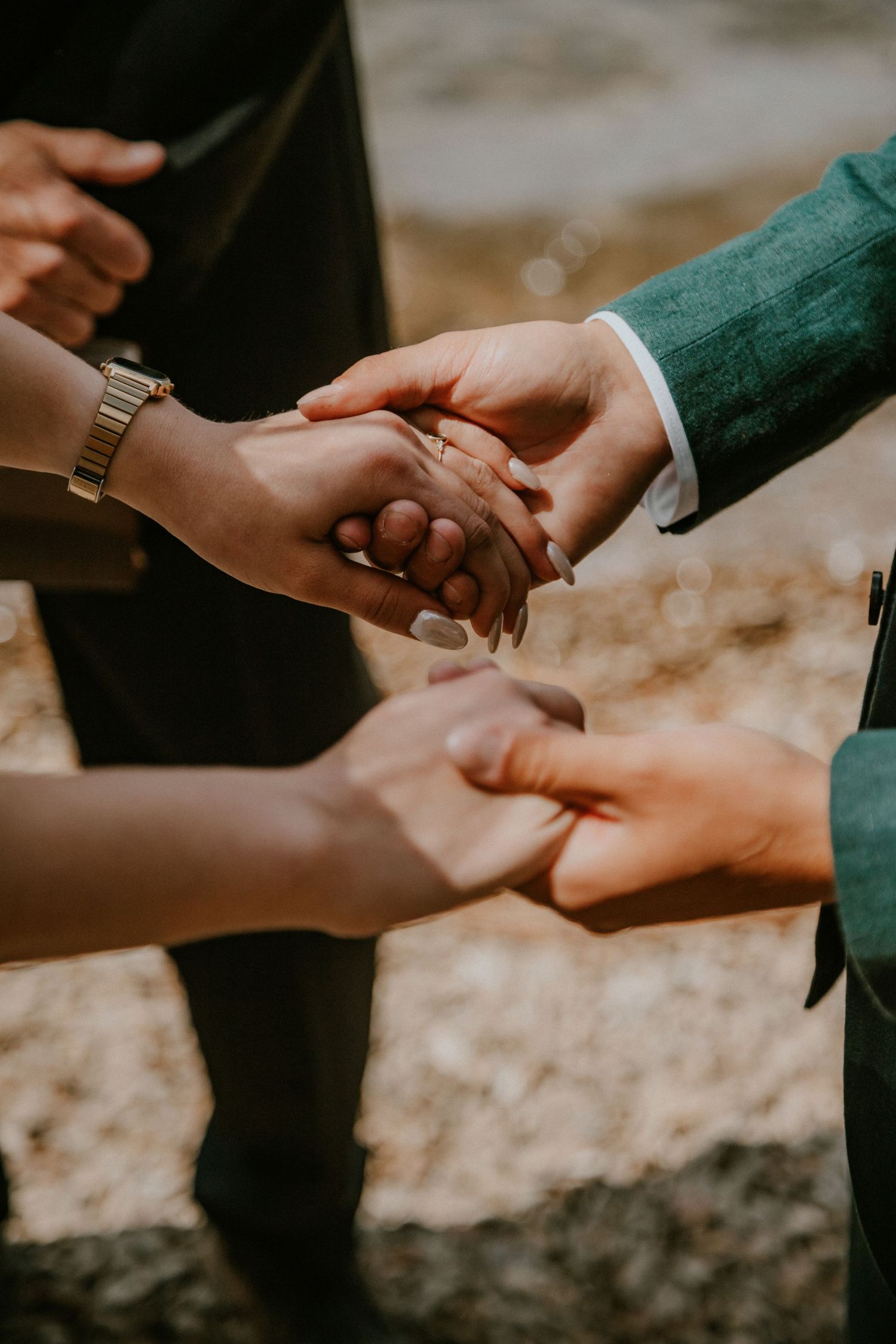 A series of photos showing hands with rings being held together in an intimate outdoor setting with soft lighting.