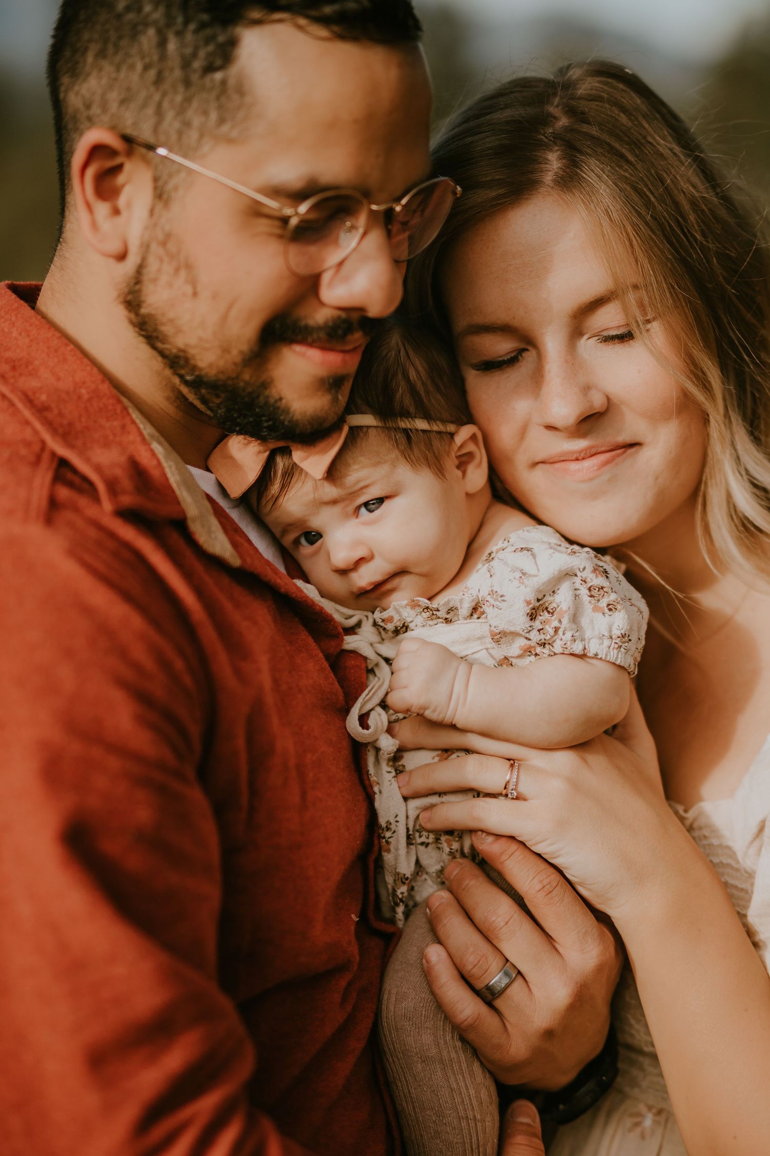 Intimate family portrait series in warm tones showing tender moments between parents and child.
