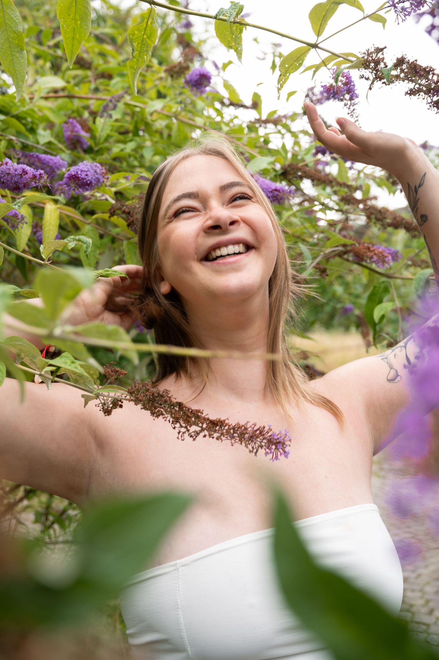 À Liège, au fort de la Chartreuse, portrait d’une femme entourée de fleurs, souriante, lors d’une séance photo en extérieur