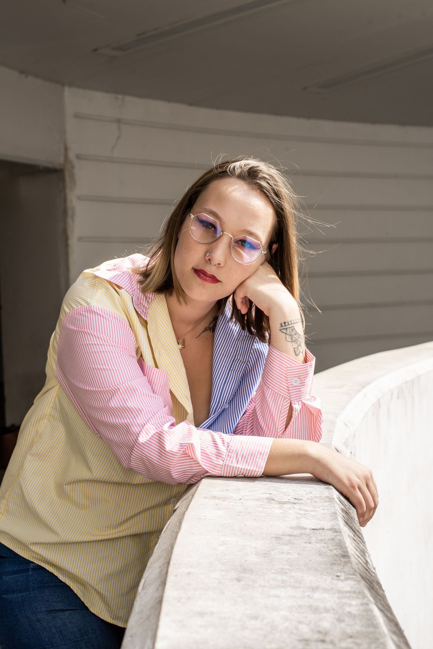 À Liège, à la gare des Guillemins, portrait d’une femme accoudée au bord du bâtiment emblématique de la gare