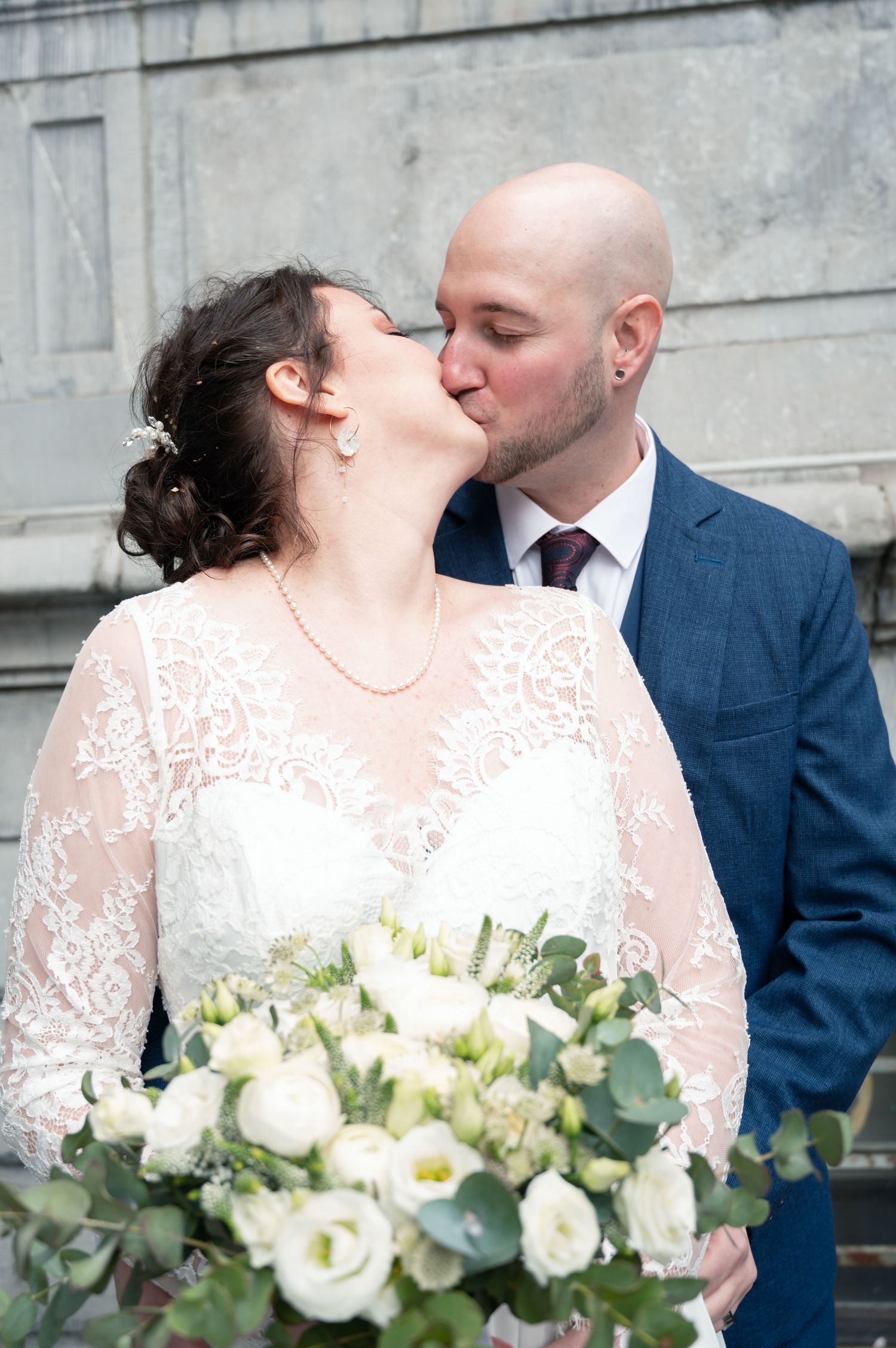 À Liège, devant l’Hôtel de Ville, couple de mariés s’embrassant lors de la journée de mariage