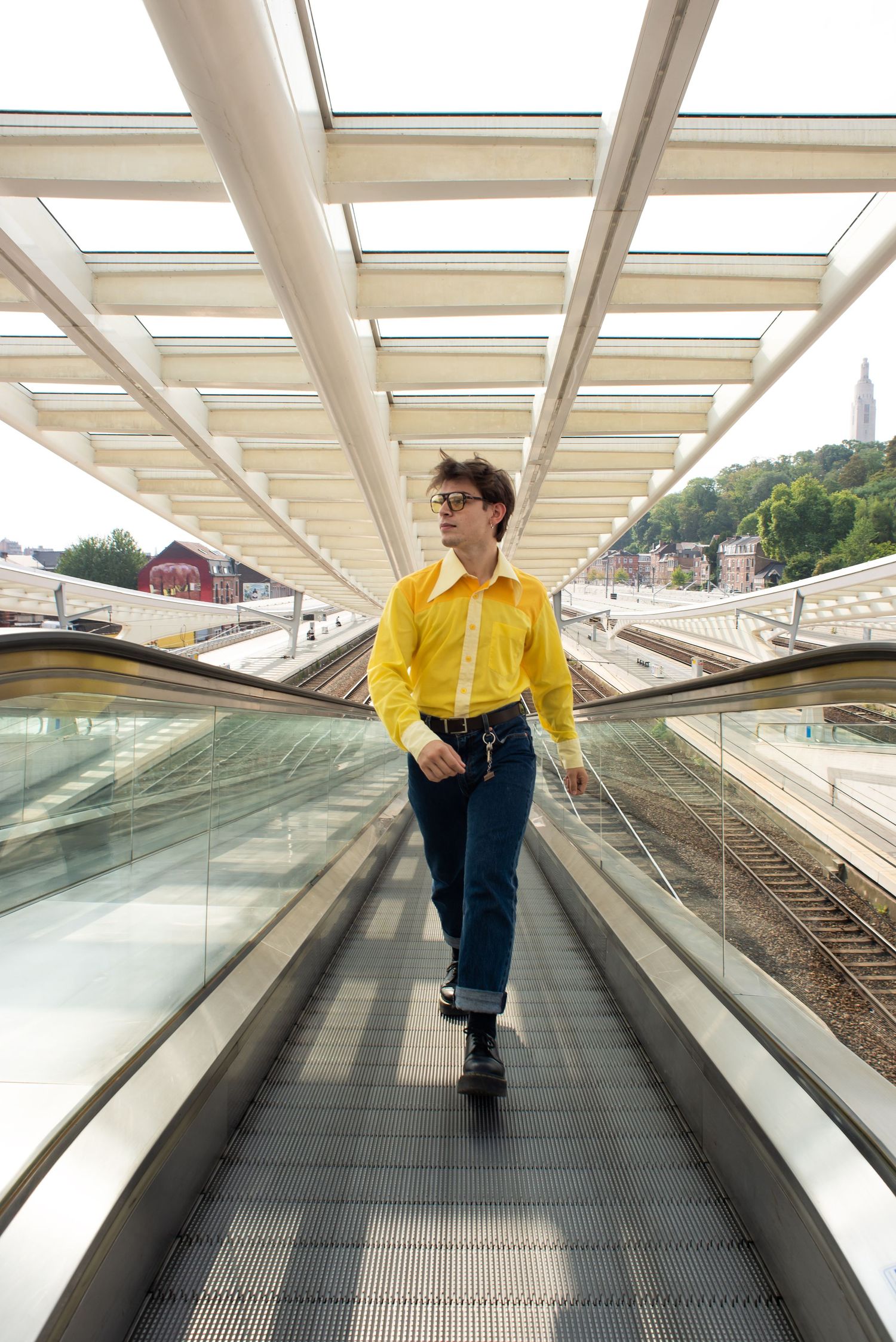 À Liège, à la gare des Guillemins, portrait urbain d’un homme marchant dans les escalators de la gare