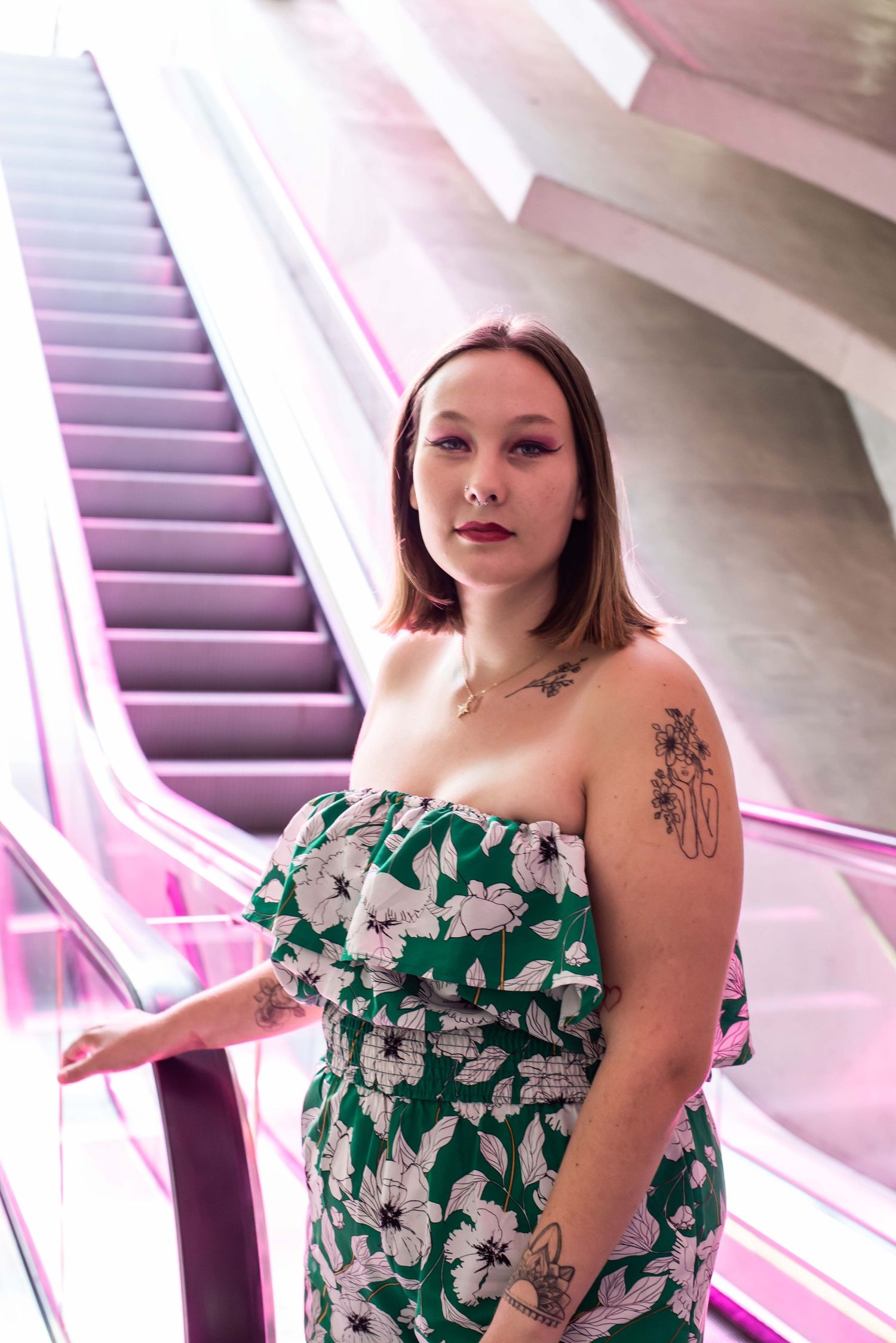 À Liège, à la gare des Guillemins, portrait d’une femme devant un escalator coloré par l’œuvre de Daniel Buren