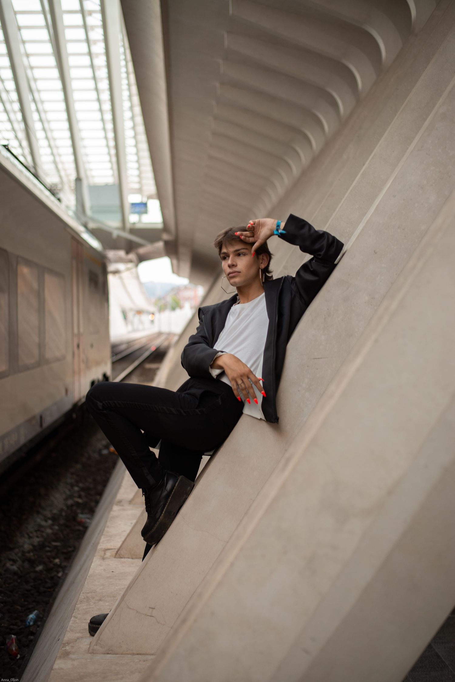 À Liège, à la gare des Guillemins, portrait d’un homme photographié à proximité des rails et des colonnes de la gare
