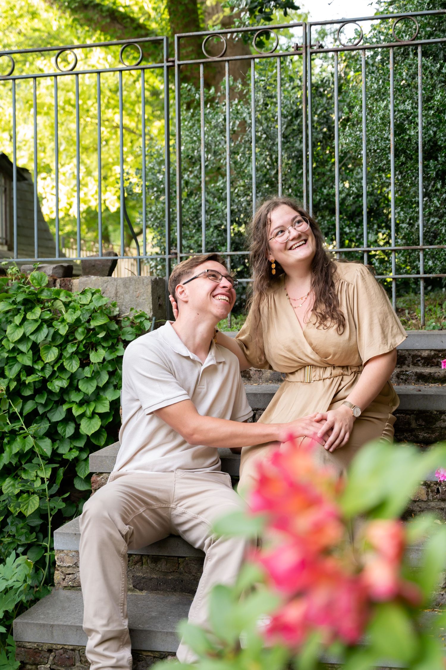 Couple photographié dans son jardin à Liège regardant au loin avec un sourire naturel lors d’une séance photo