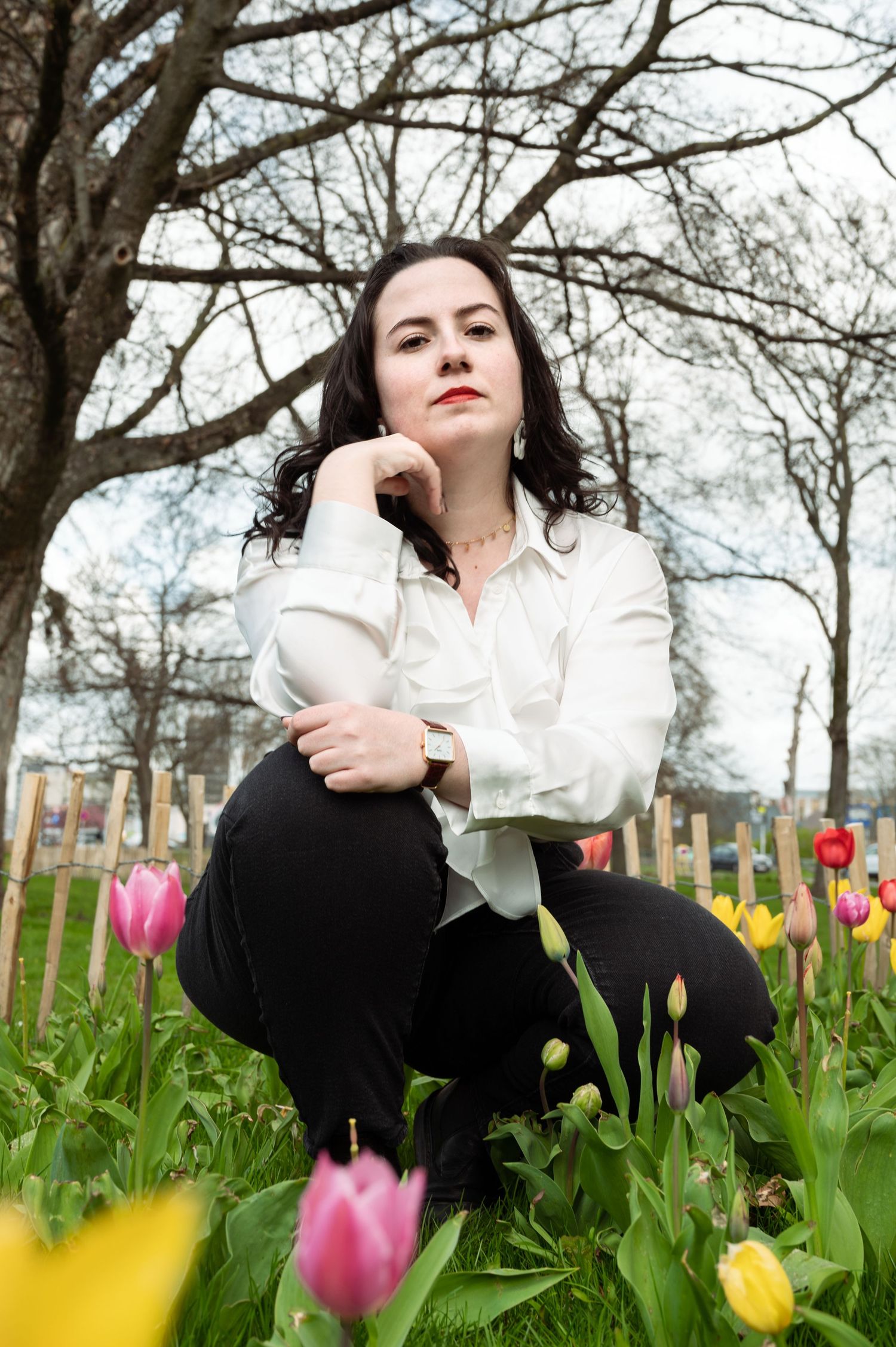 Séance photo d'une femme assise parmi les tulipes dans le parc de la Boverie à Liège