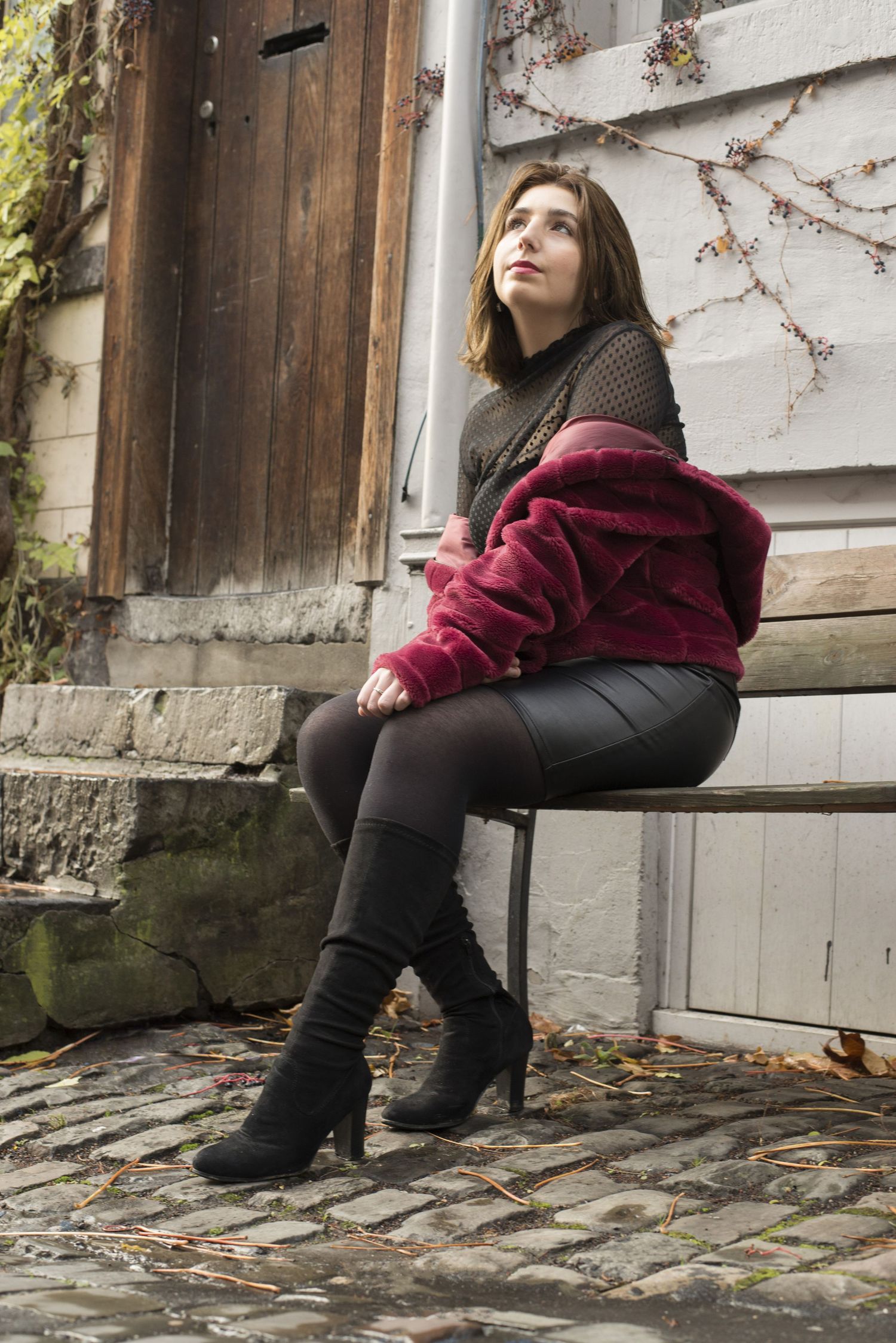 À Liège, portrait d’une femme assise sur un banc, regardant au loin lors d’une séance photo urbaine
