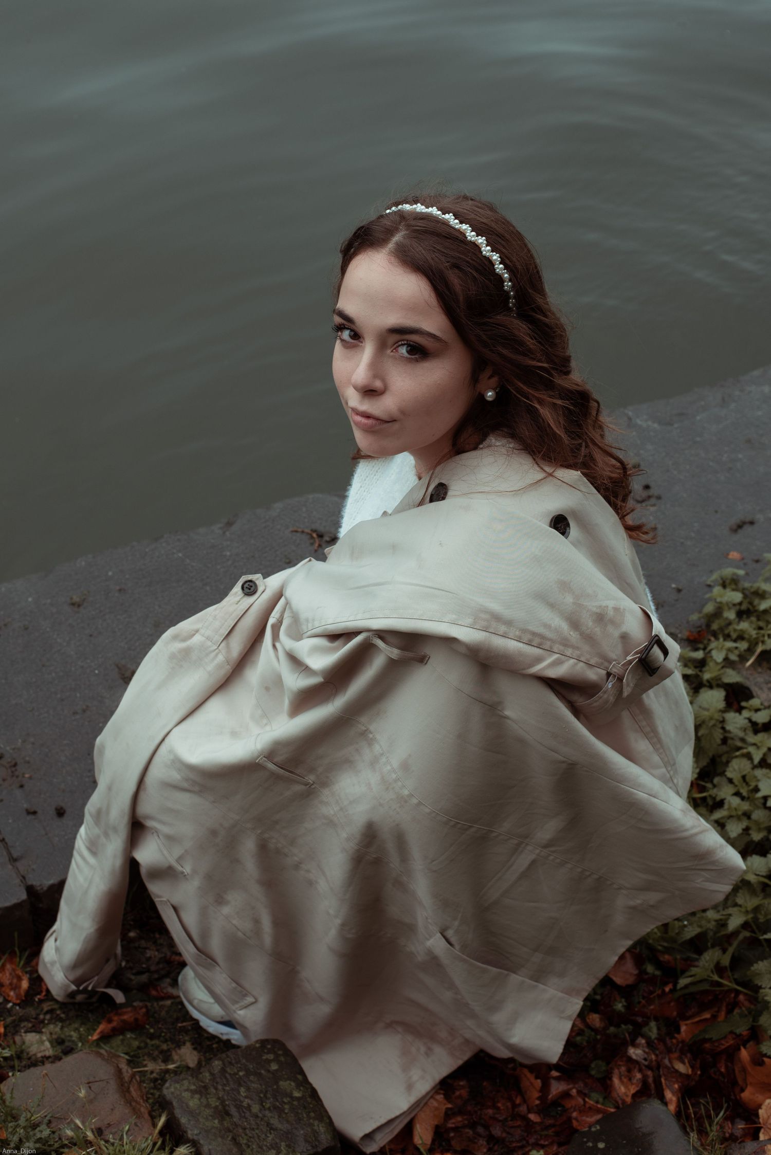 À Liège, au pont de Fragnée, portrait d’une femme accroupie au bord de la Meuse lors d’une séance photo en extérieur