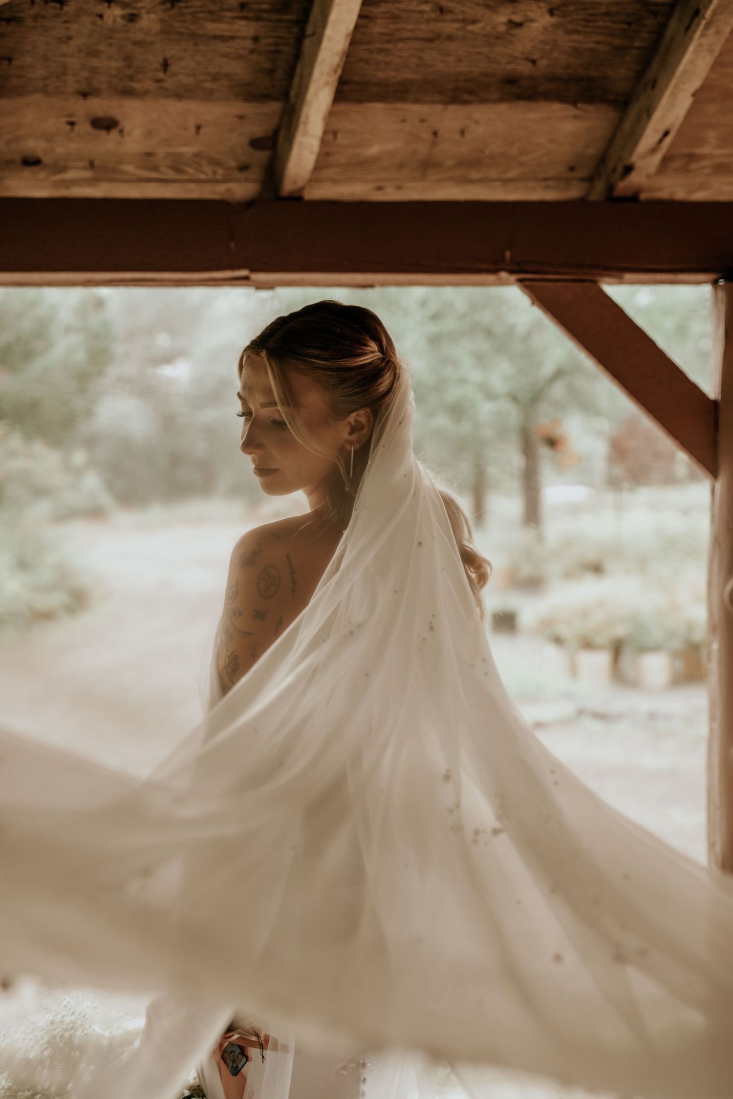 A flowing white wedding dress twirls gracefully in a rustic wooden setting, creating an ethereal motion effect.