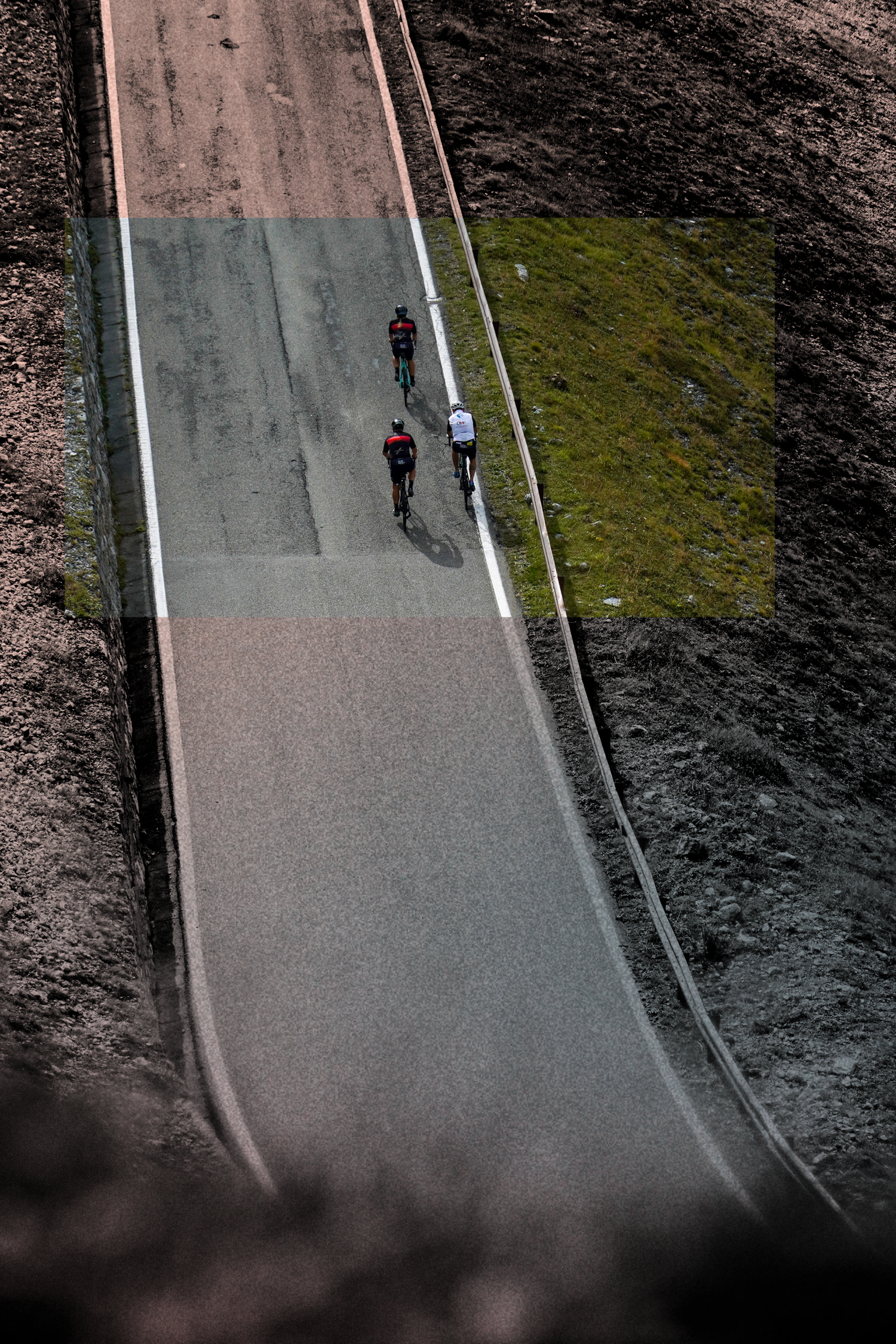Two cyclists ride along a steep concrete path with grassy slopes on either side.