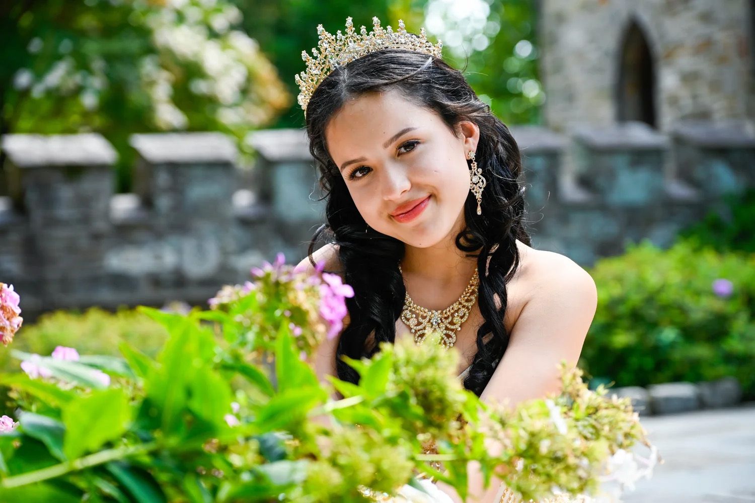 Quinceañera smiling in the gardens of The Cloisters Castle.