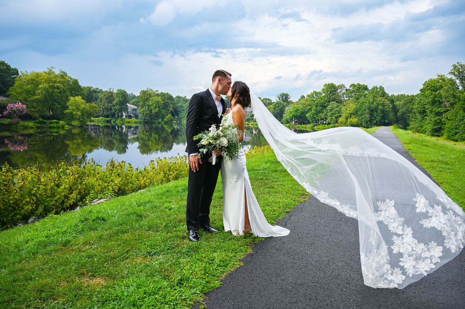 Couple sharing a romantic kiss as the veil flows softly around them.